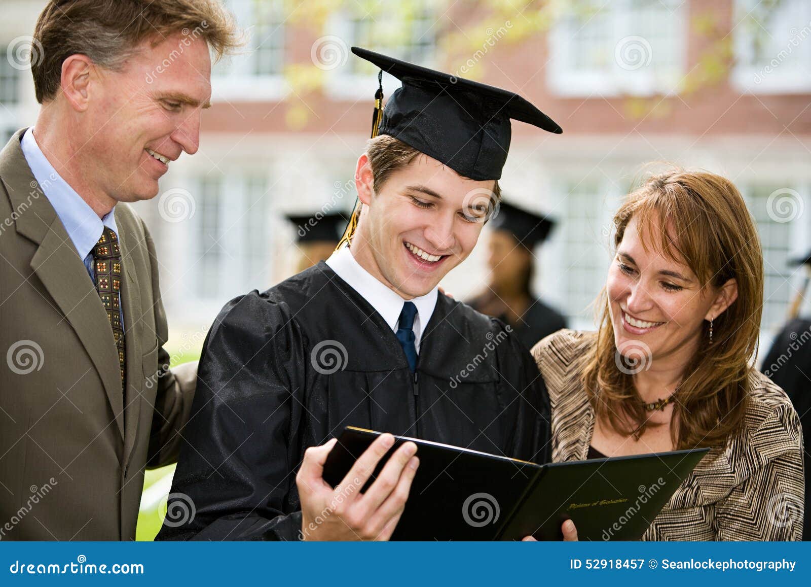 Graduacion La Familia Orgullosa Admira El Diploma Imagen De