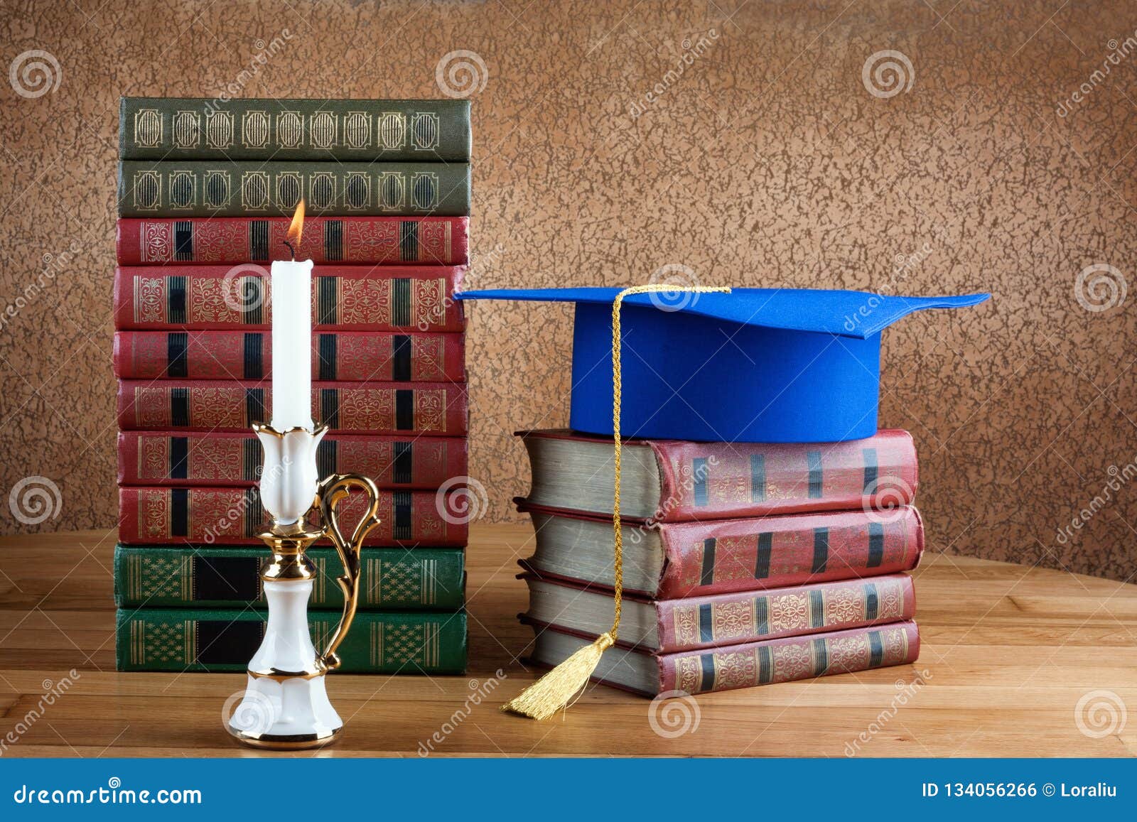Graduation Mortarboard On Top Of Stack Of Books On Wooden Table