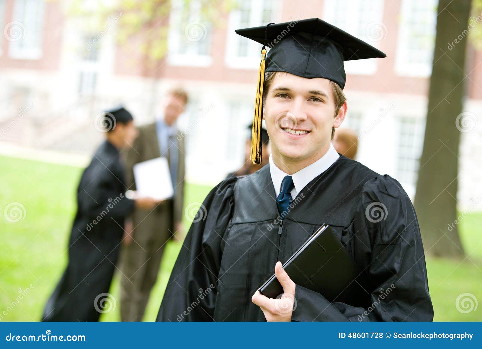 Graduation: Smart Graduate with Others Behind Stock Photo - Image of ...