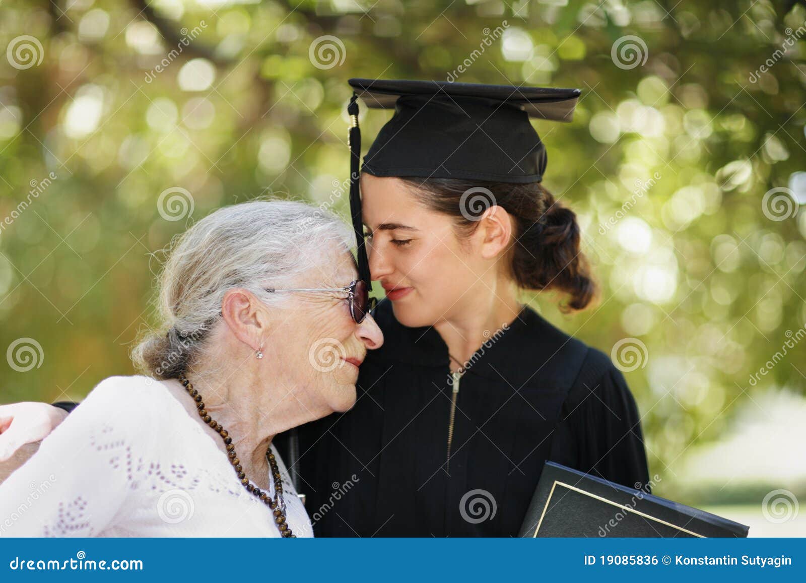 Graduação feliz. Graduado feliz com graduação selebrating do grandomther. Close up, DOF raso.