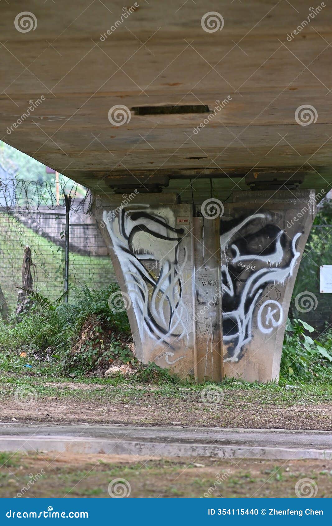 the graffiti beneath the bridge appears more vivid, its colors deepened by the moisture clinging to the rough concrete surface
