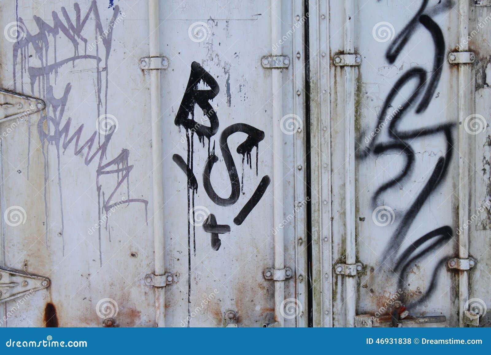 Grafittis no recipiente oxidado. Grafittis em preto e em violeta em um recipiente de carga branco e oxidado