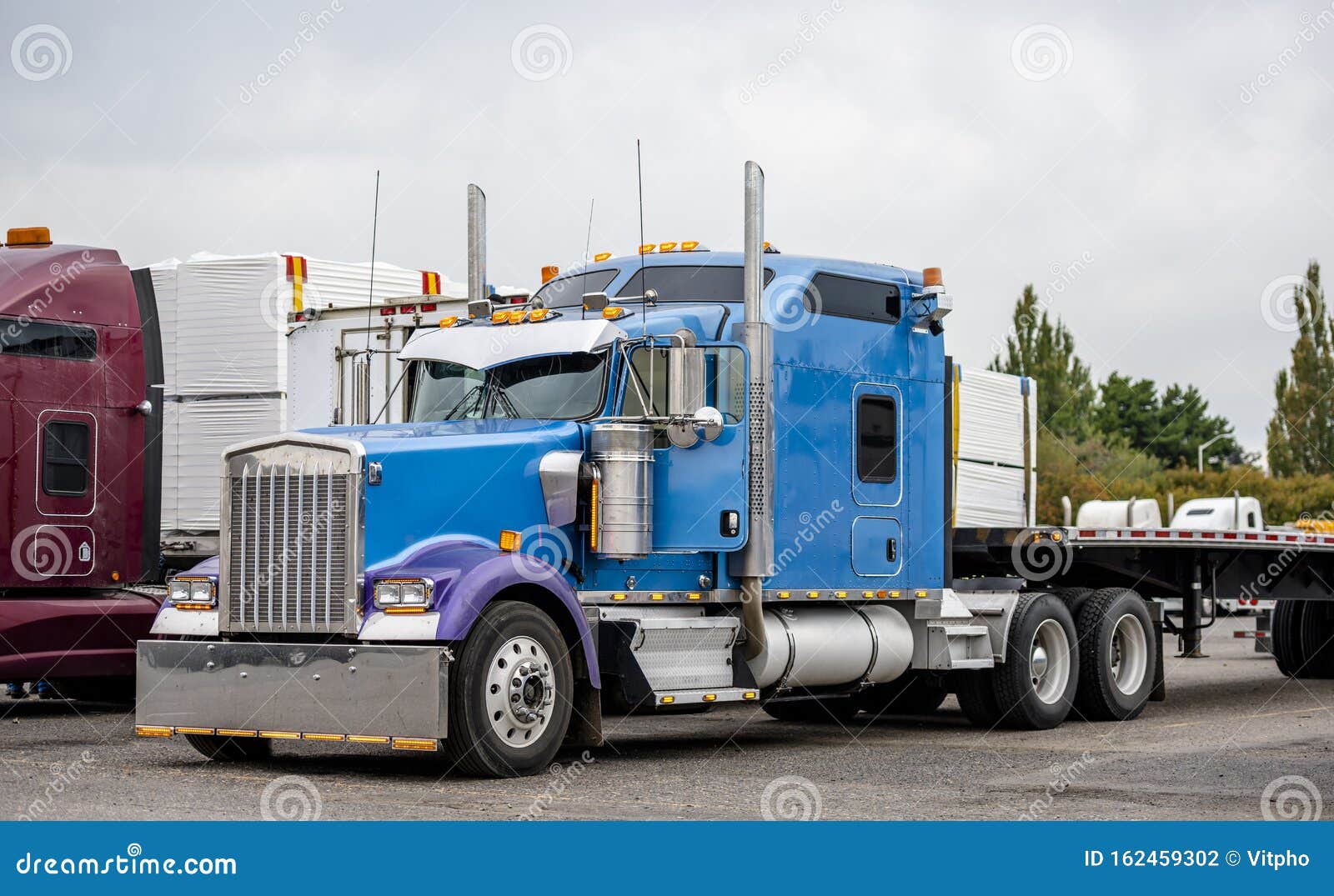 Grand classique bleu gros camion semi truck avec protection de grille  pare-choc et couverts chargement sur remorque à plateau en bois pont à  travers la rivière Columbia Photo Stock - Alamy