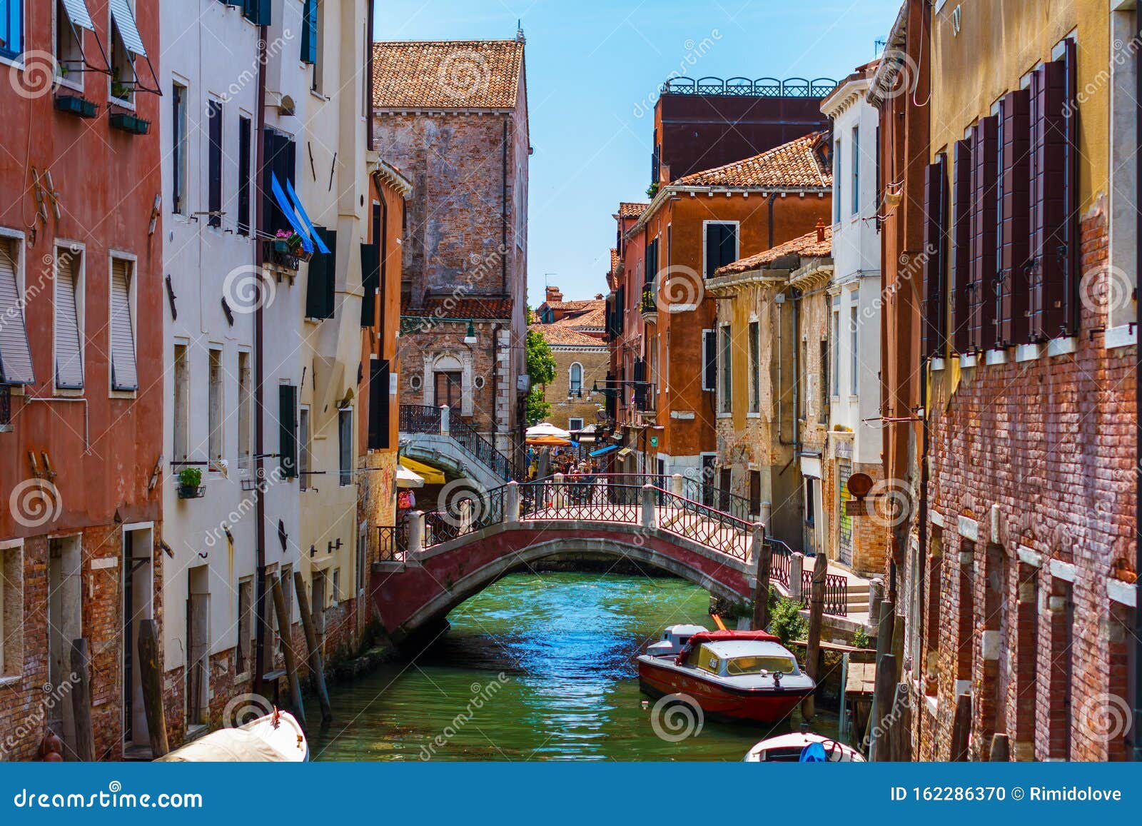 grand canal in venice with boats and gandules docket motor boat near the bridge. colorful residential house and small bridges
