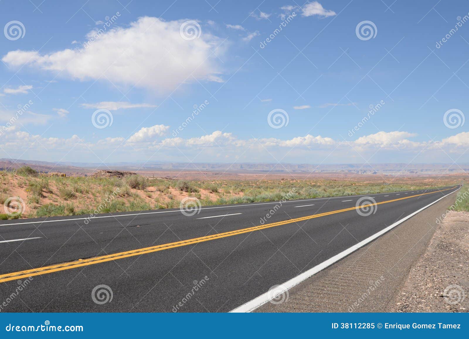 Image of a pavement road next to the Grand Canyon.