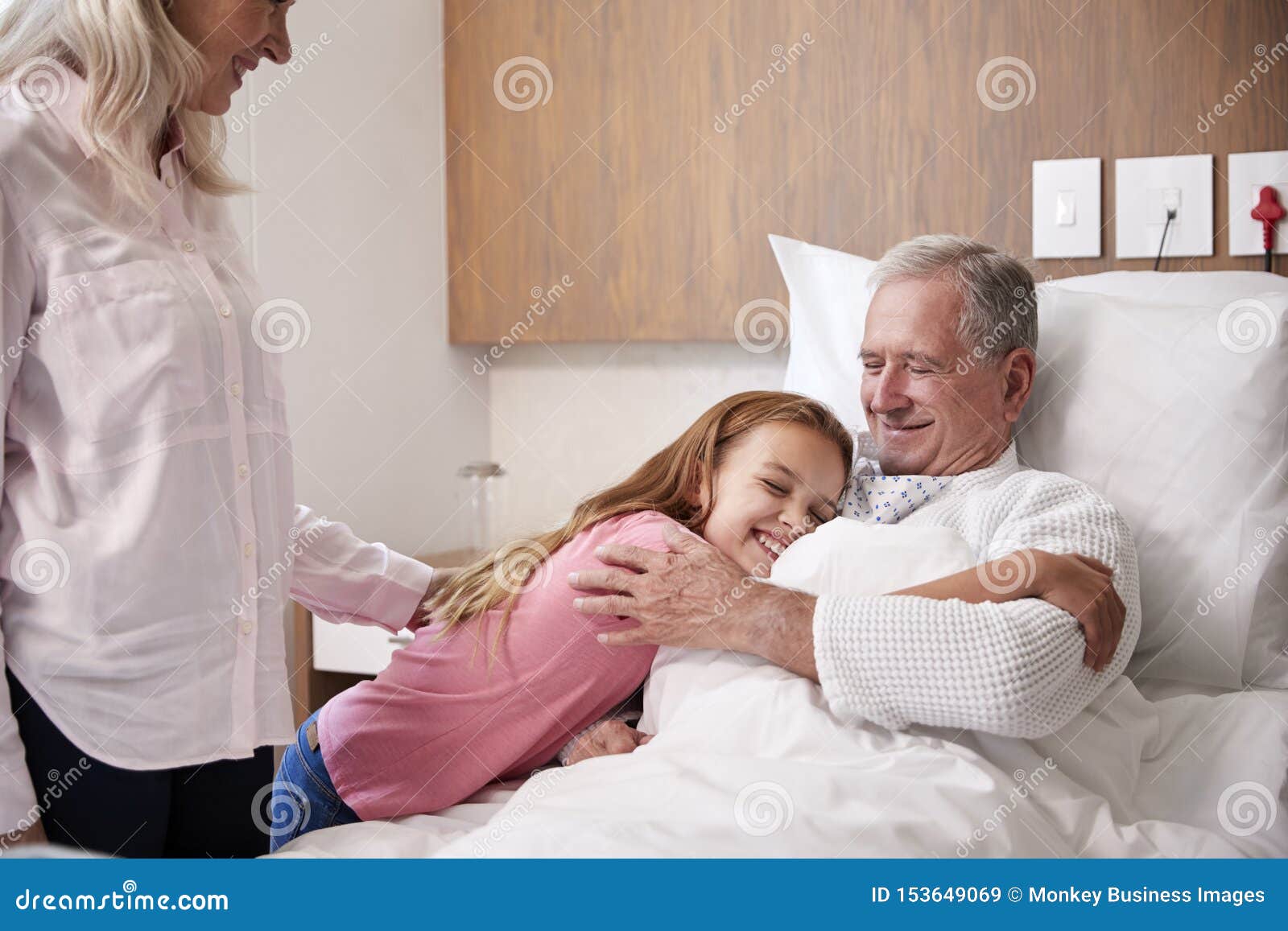 granddaughter hugging grandfather on family hospital visit