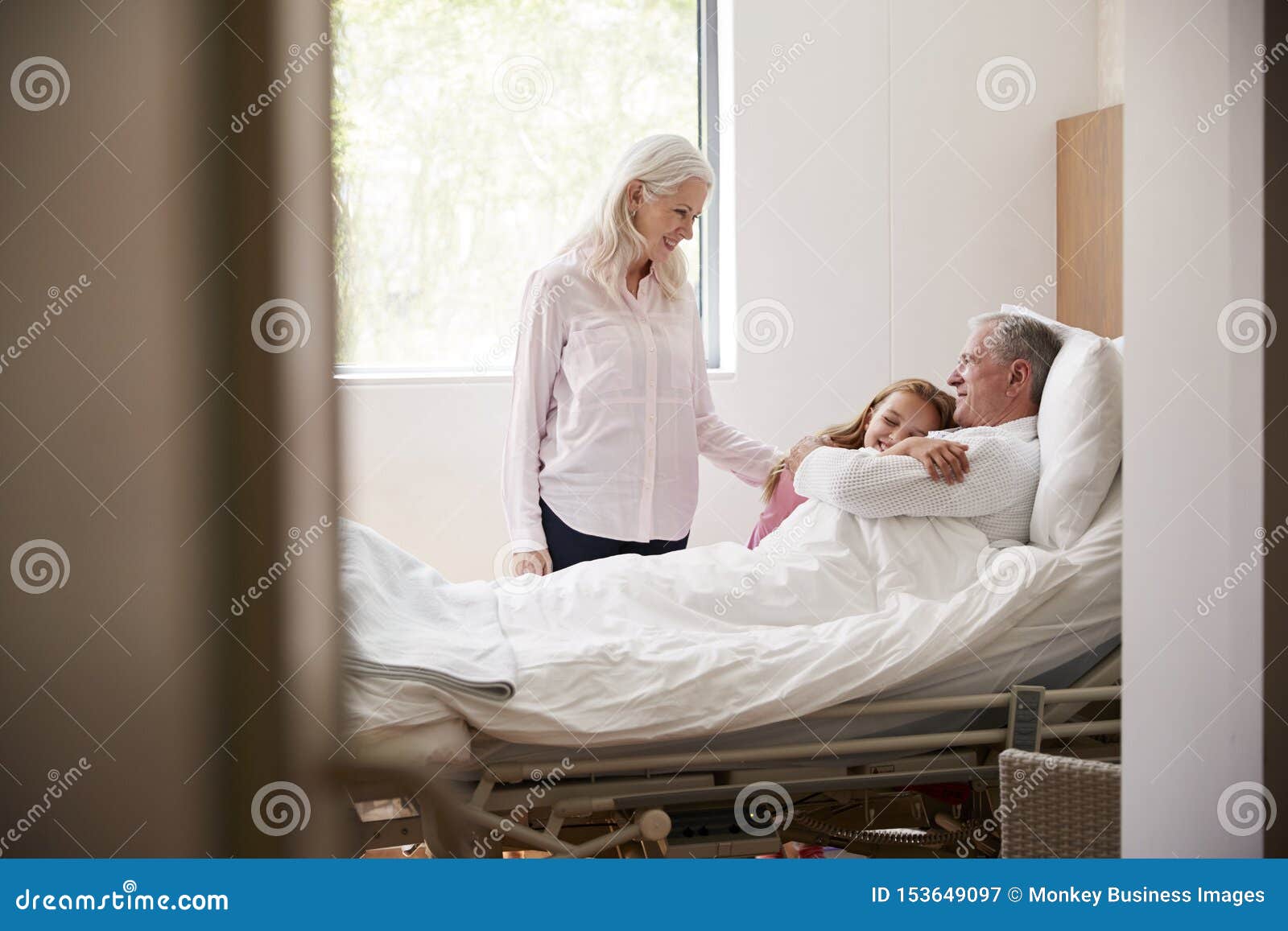 granddaughter hugging grandfather on family hospital visit