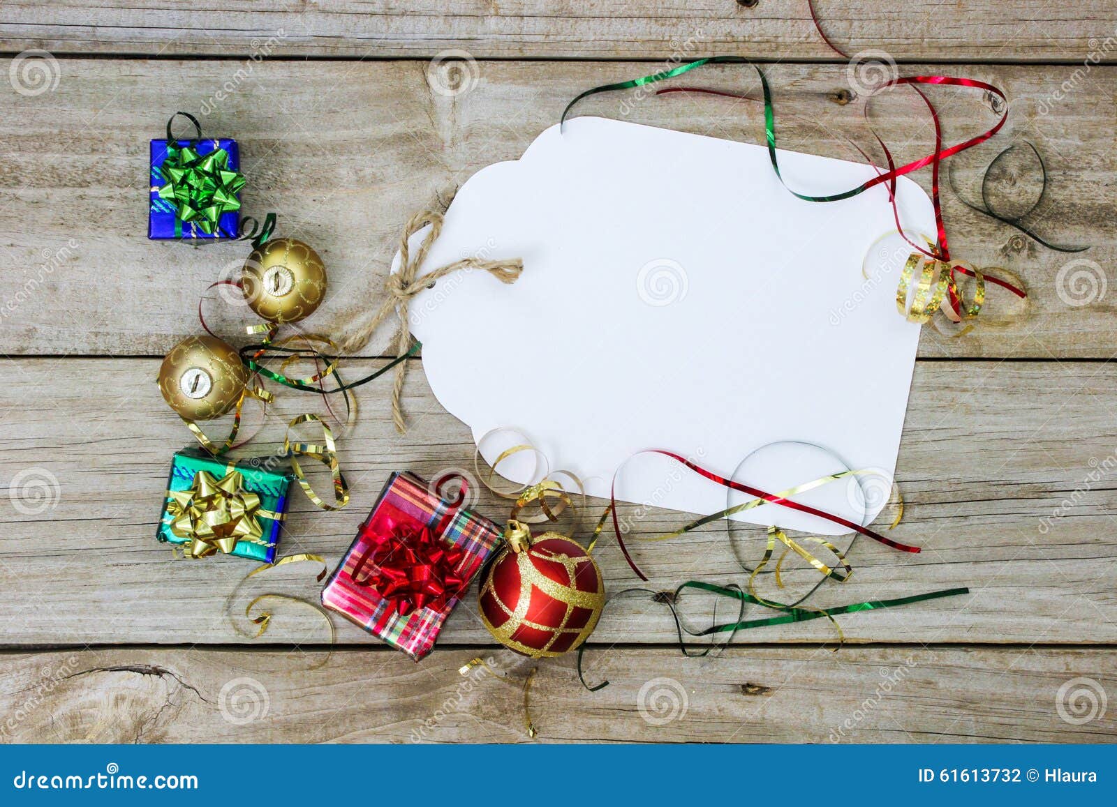 Grande étiquette de cadeau avec des décorations de vacances. Grande étiquette vide de cadeau de Noël blanc par des présents, des ornements et le ruban sur le fond en bois rustique antique ; au-dessus de la vue regardant vers le bas