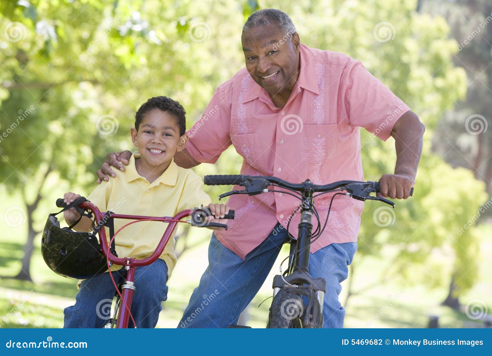 grandfather and grandson on bikes outdoors smiling