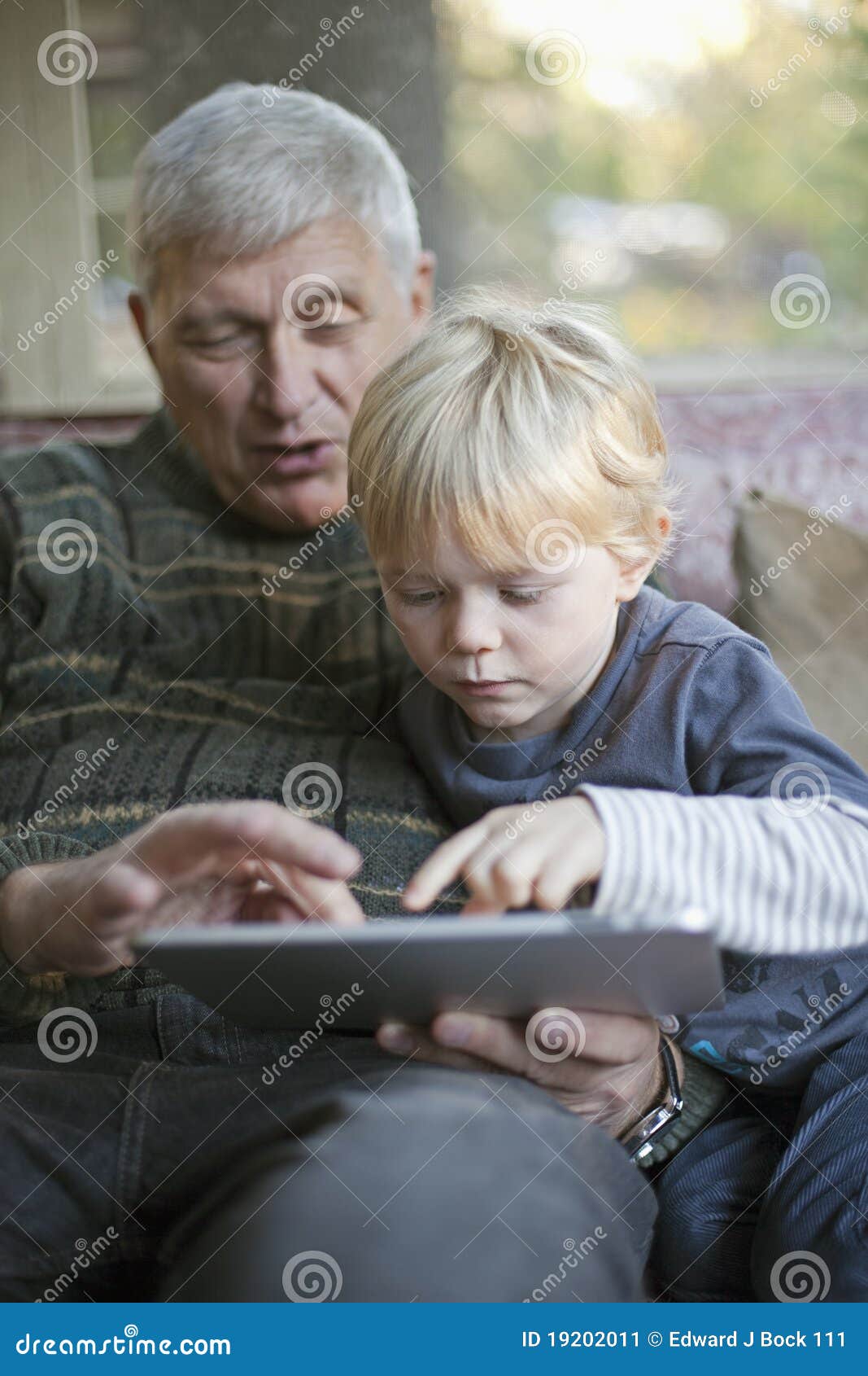 grandfather and grandson using tablet pc