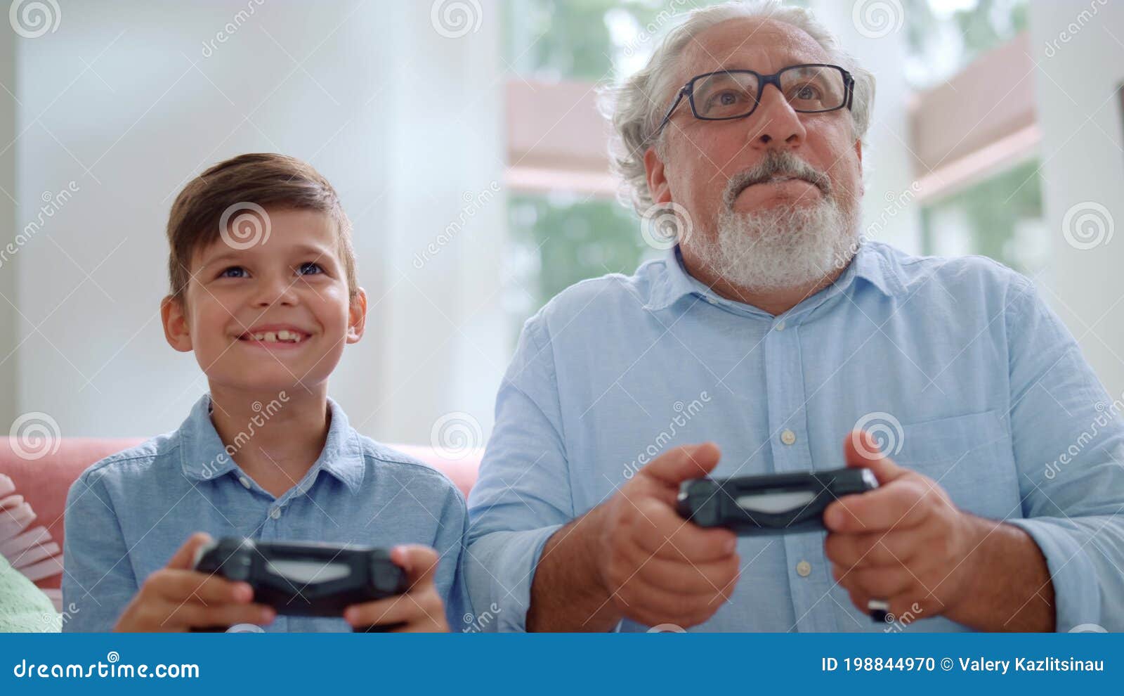 Grandfather Playing Video Game with Grandson. Mature Man and Boy Using