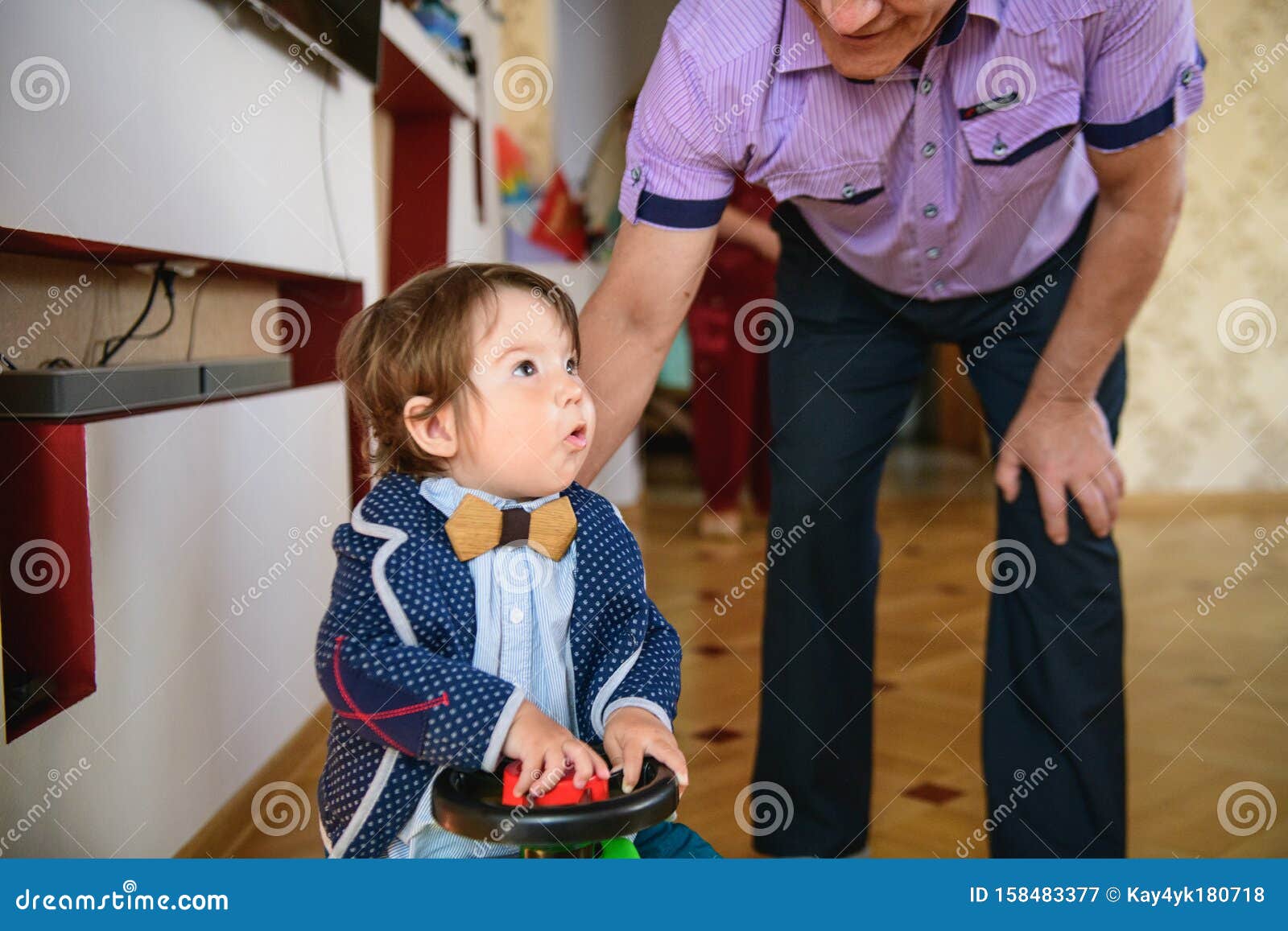 grandfather rolls grandson in a toy car. redirection of grandfather and grandson. happy weekend concept. happy grandfather and