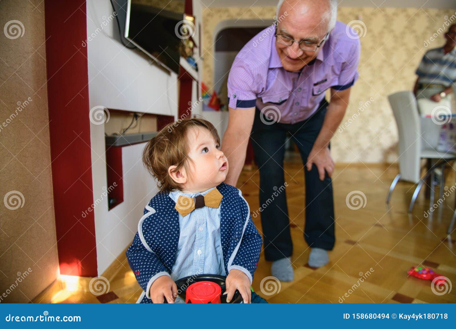 grandfather rolls grandson in a toy car. redirection of grandfather and grandson. happy weekend concept. happy grandfather and