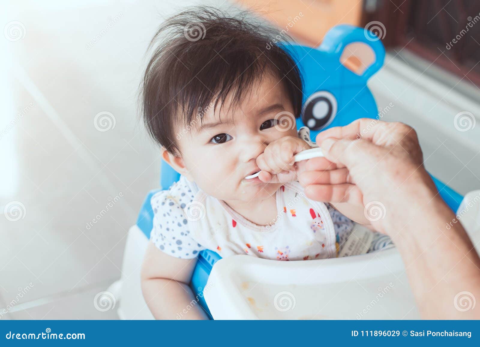 Grandmother Feeding Cute Asian Baby Girl With A Spoon Stock Image