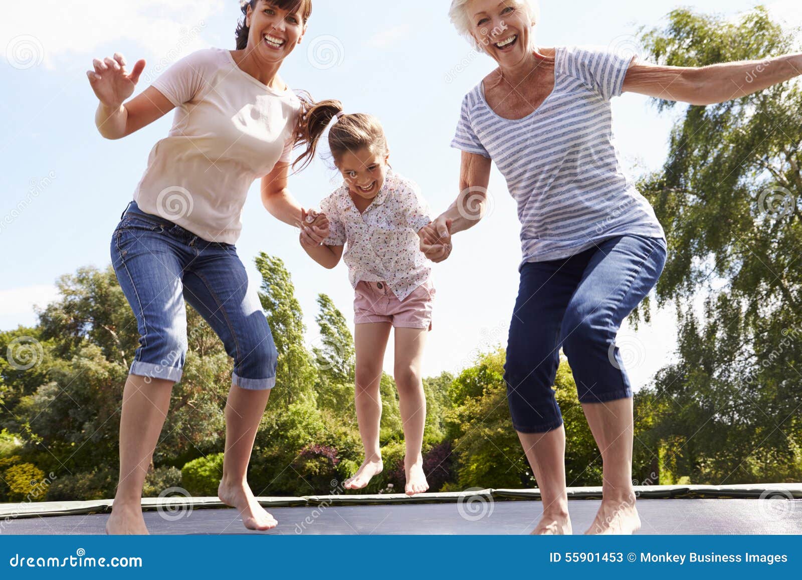 grandmother, granddaughter and mother bouncing on trampoline