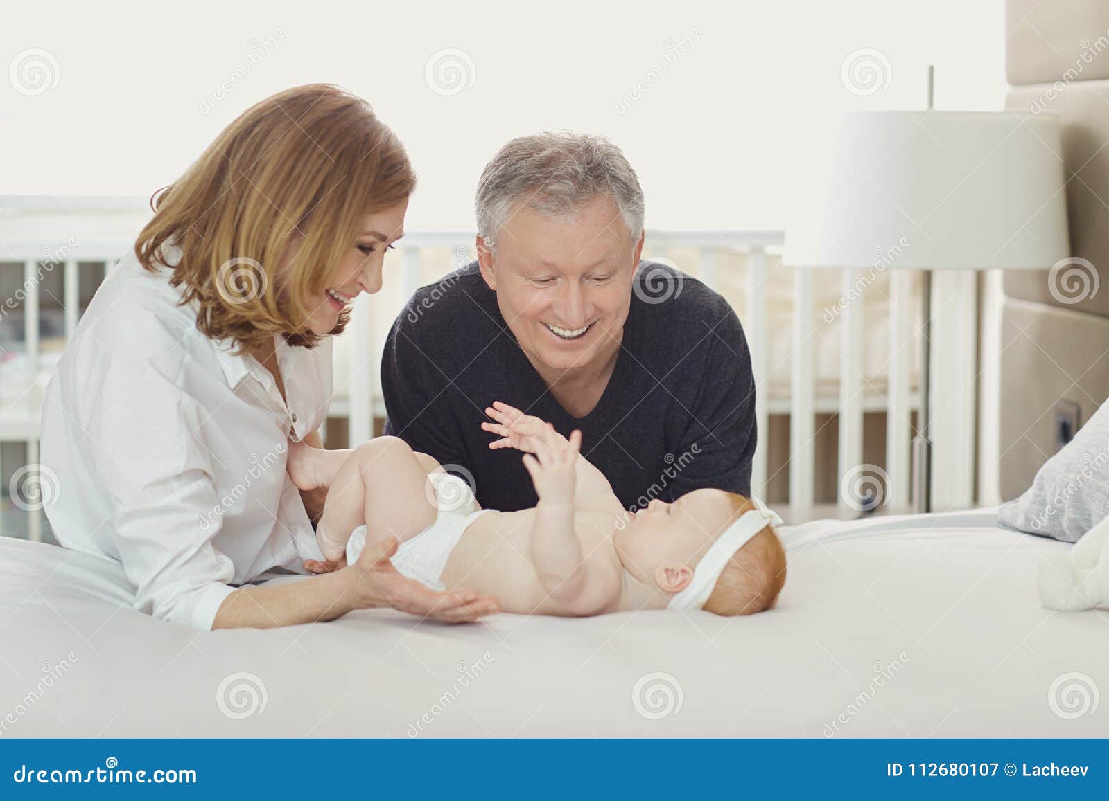 Grandparents and the Baby are Playing on the Bed. Stock Image Image