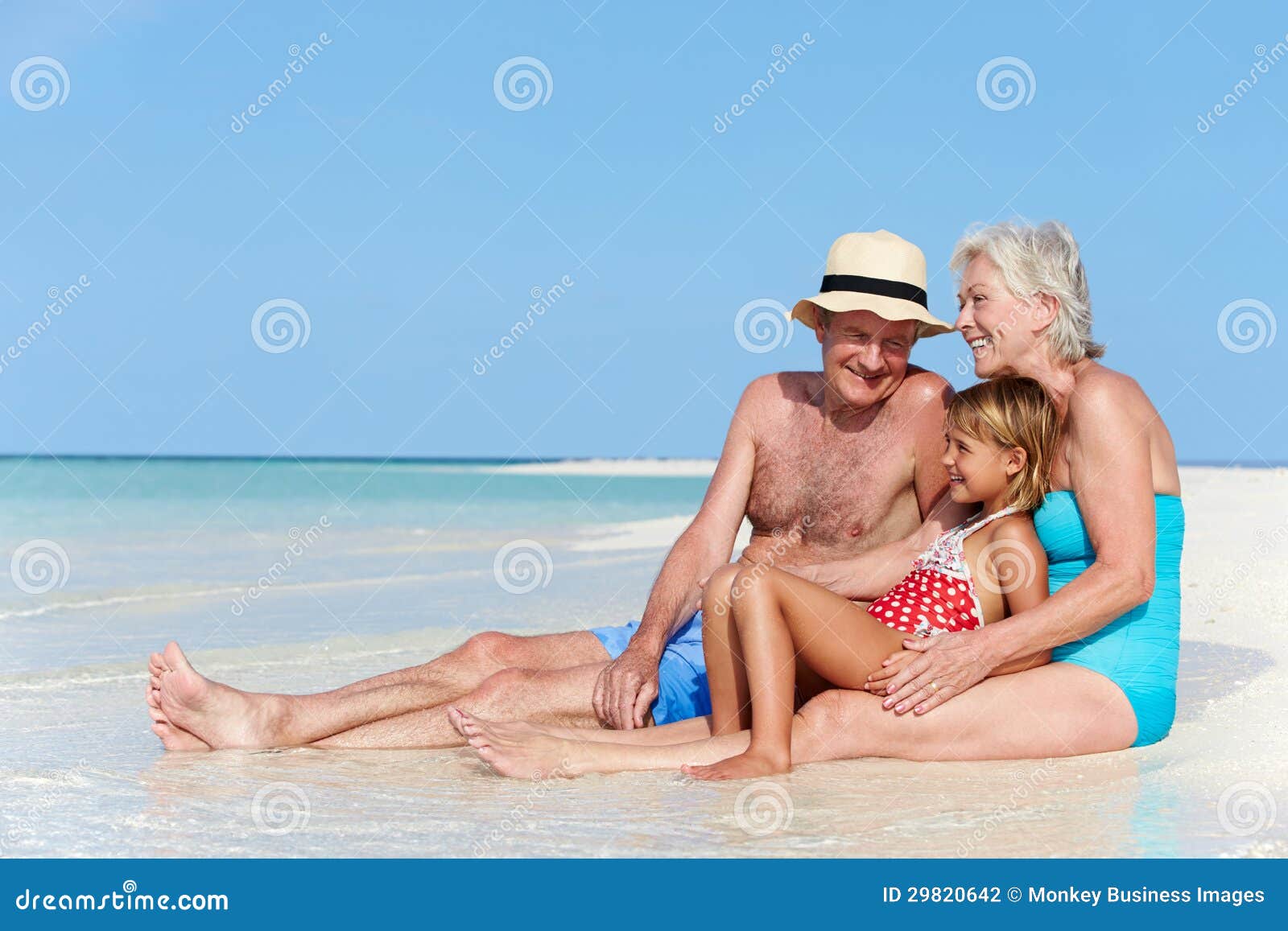 grandparents with granddaughter enjoying beach holiday