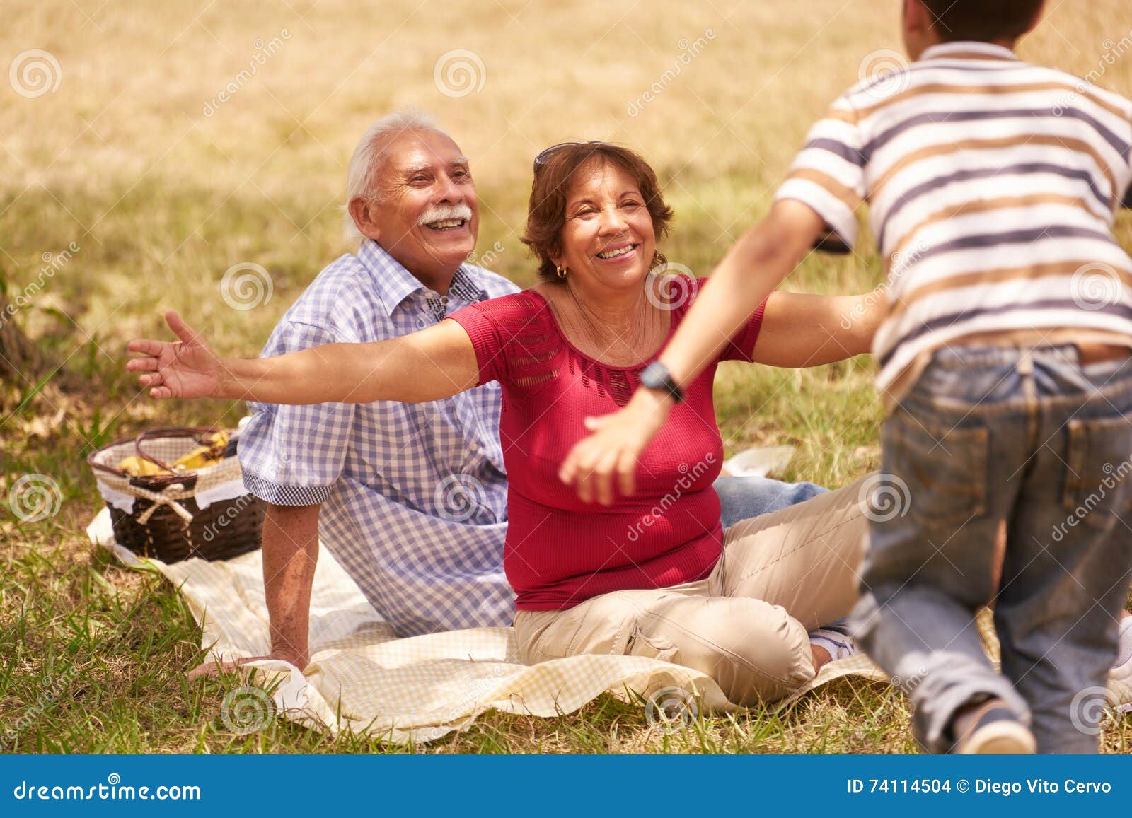 grandparents senior couple hugging young boy at picnic