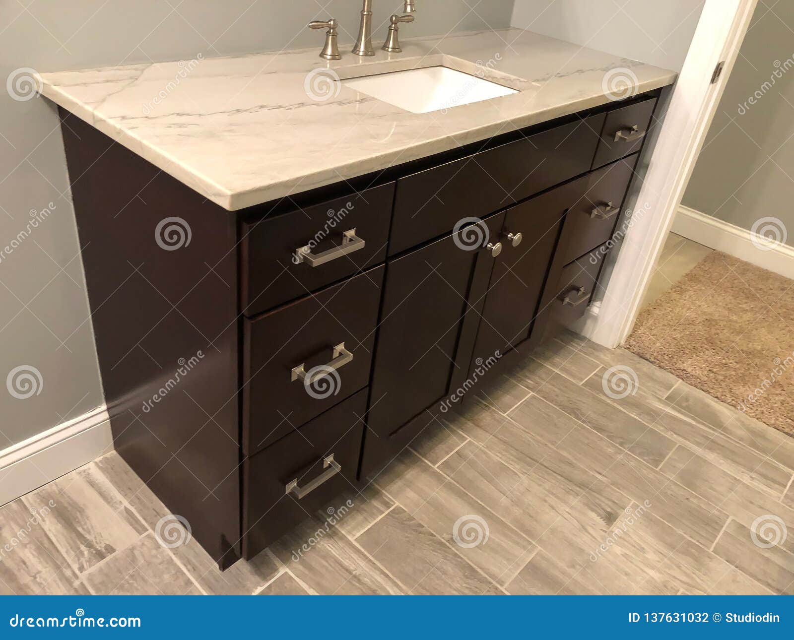 Granite Countertop With White Sink And Chrome Faucet On Dark Wood