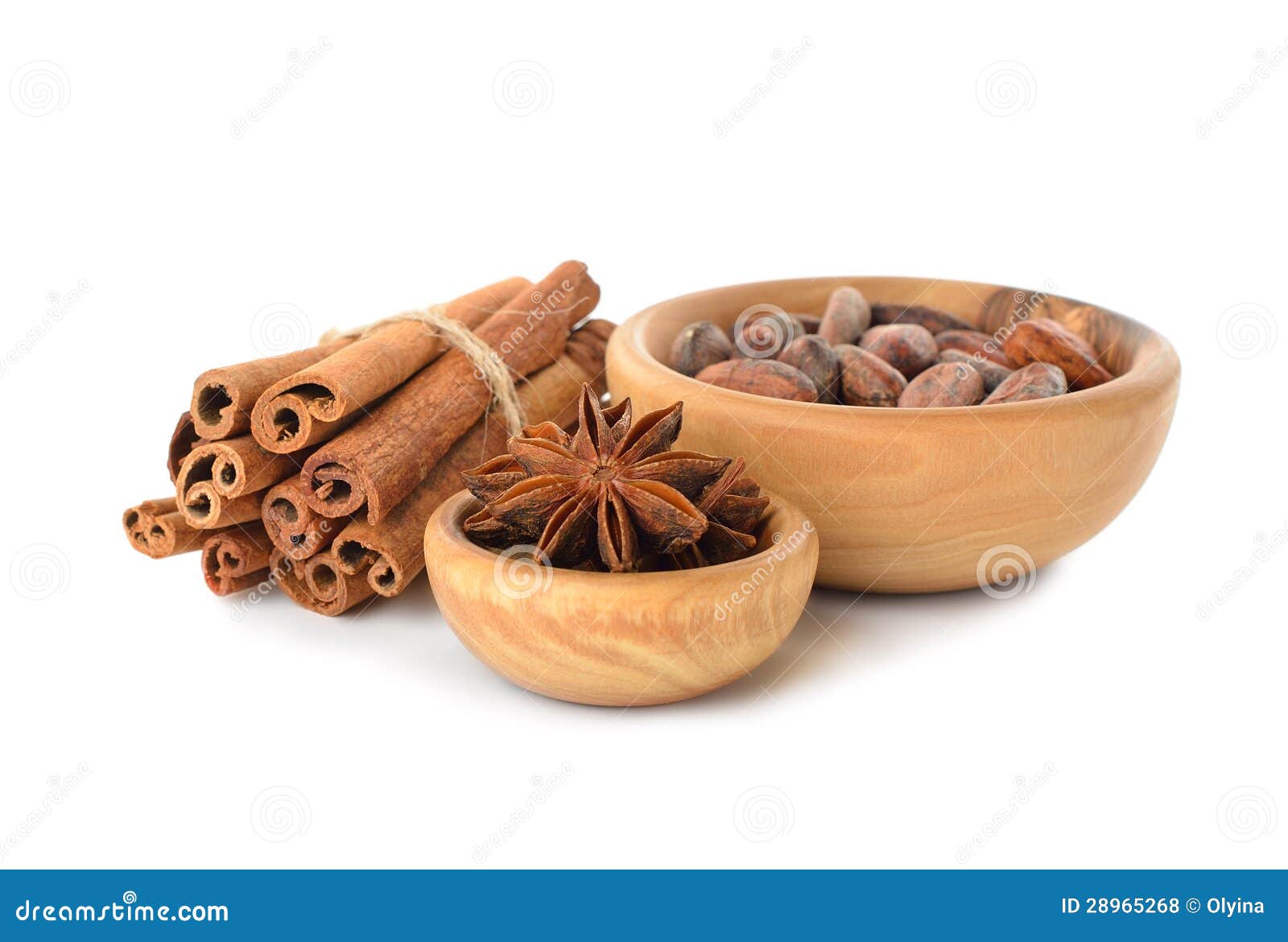 Granos del canela, del anís y de cacao en un cuenco de madera