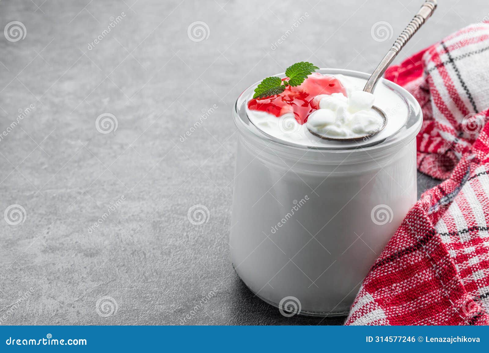 granular cottage cheese with cream and berry jam on gray background