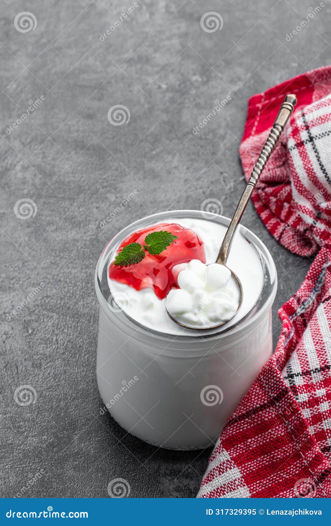 granular cottage cheese with cream and berry jam on gray background