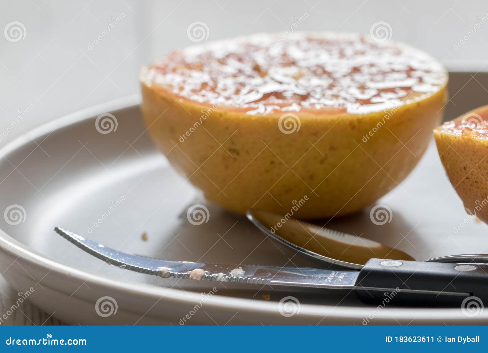 Grapefruit Knife and Spoon in Front of Grilled Grapefruit Focus on