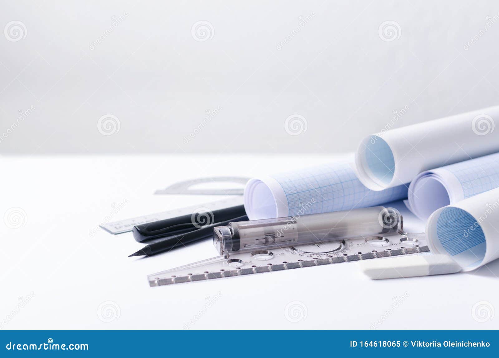 graph paper, t-square, rulers on the white constructor`s worplace against white wall.empty space for text