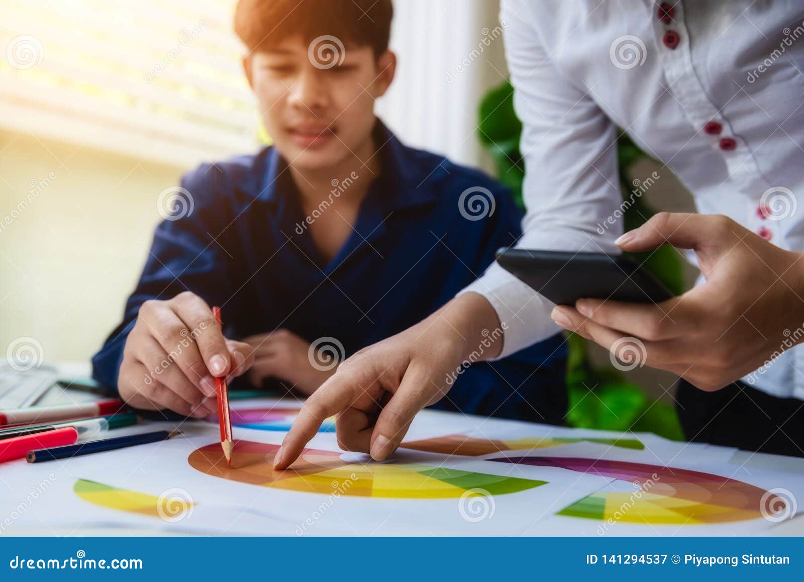 Graphic Designer Using Color Swatch Sample with Mobile Phone on Artist