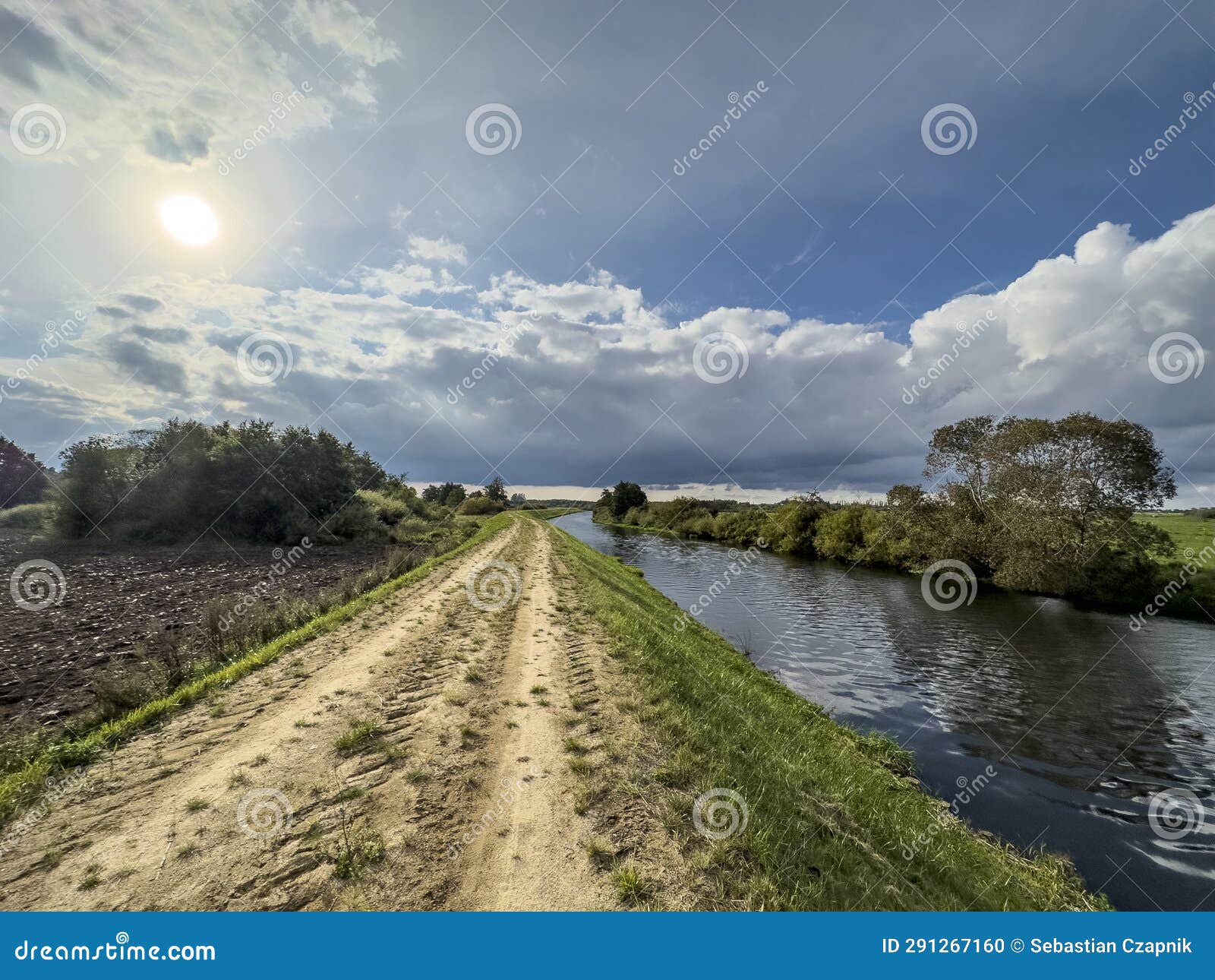 grass covered dike of wieprza river in poland on a sunny late summer day