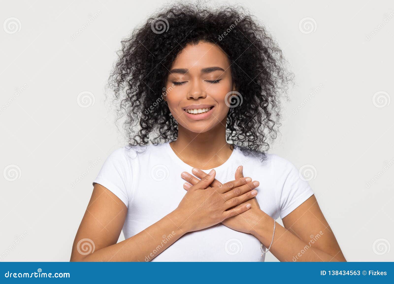 grateful happy black woman holding hands on chest feeling thankful
