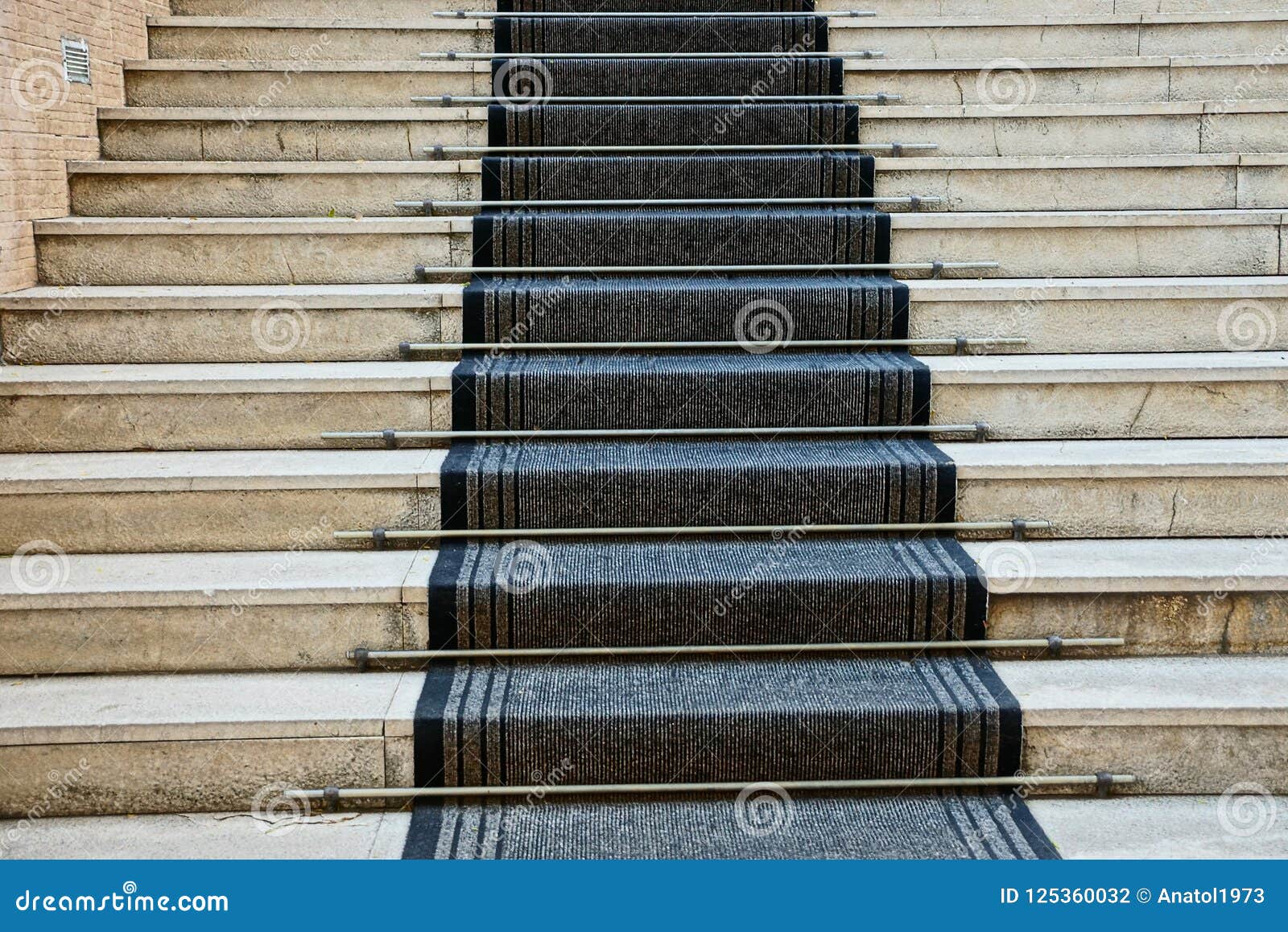 Gray Concrete Steps of the Stairs and Black Carpet Track Stock Photo