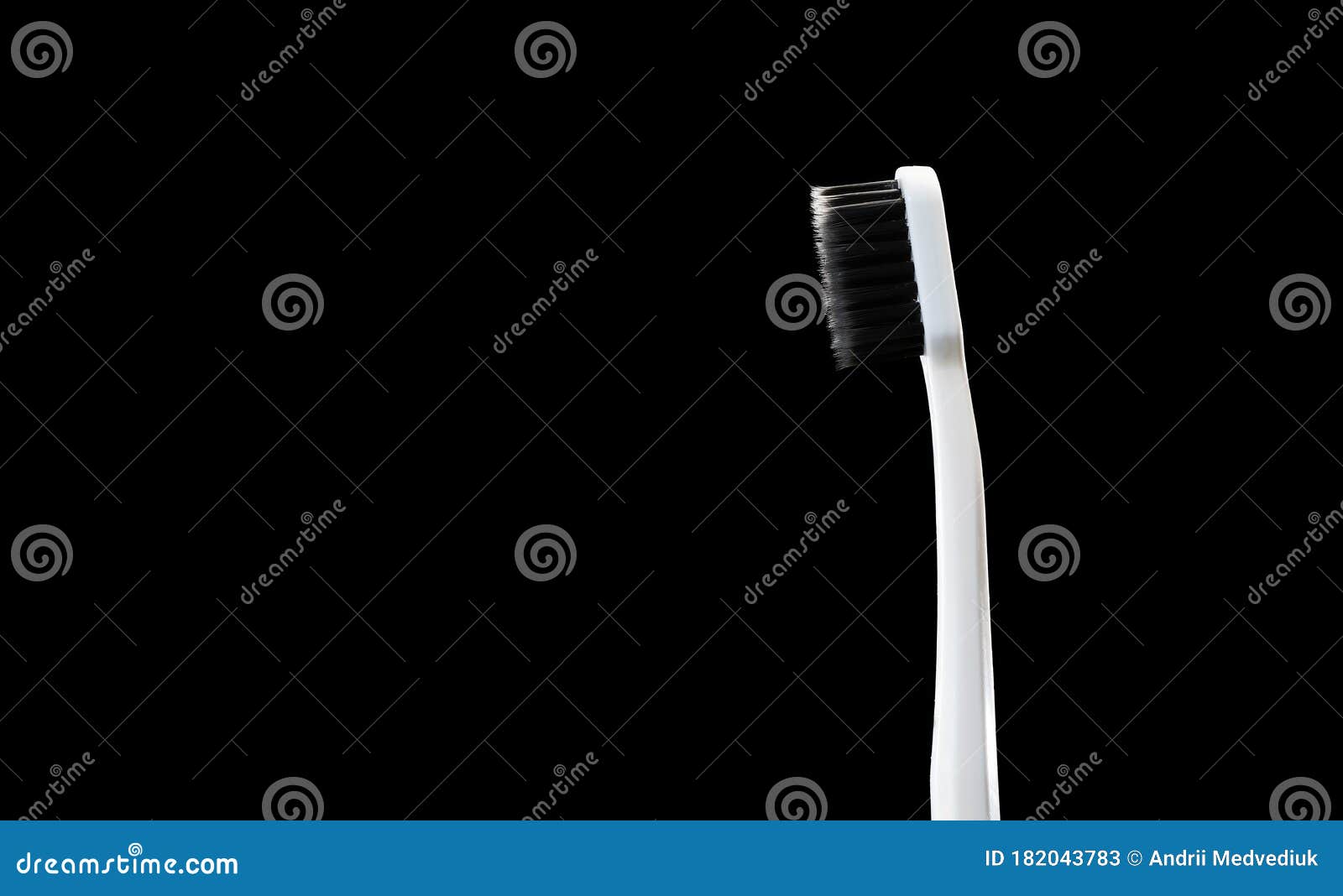 Gray Toothbrush with Black Bristles on a Black Background Stock Image