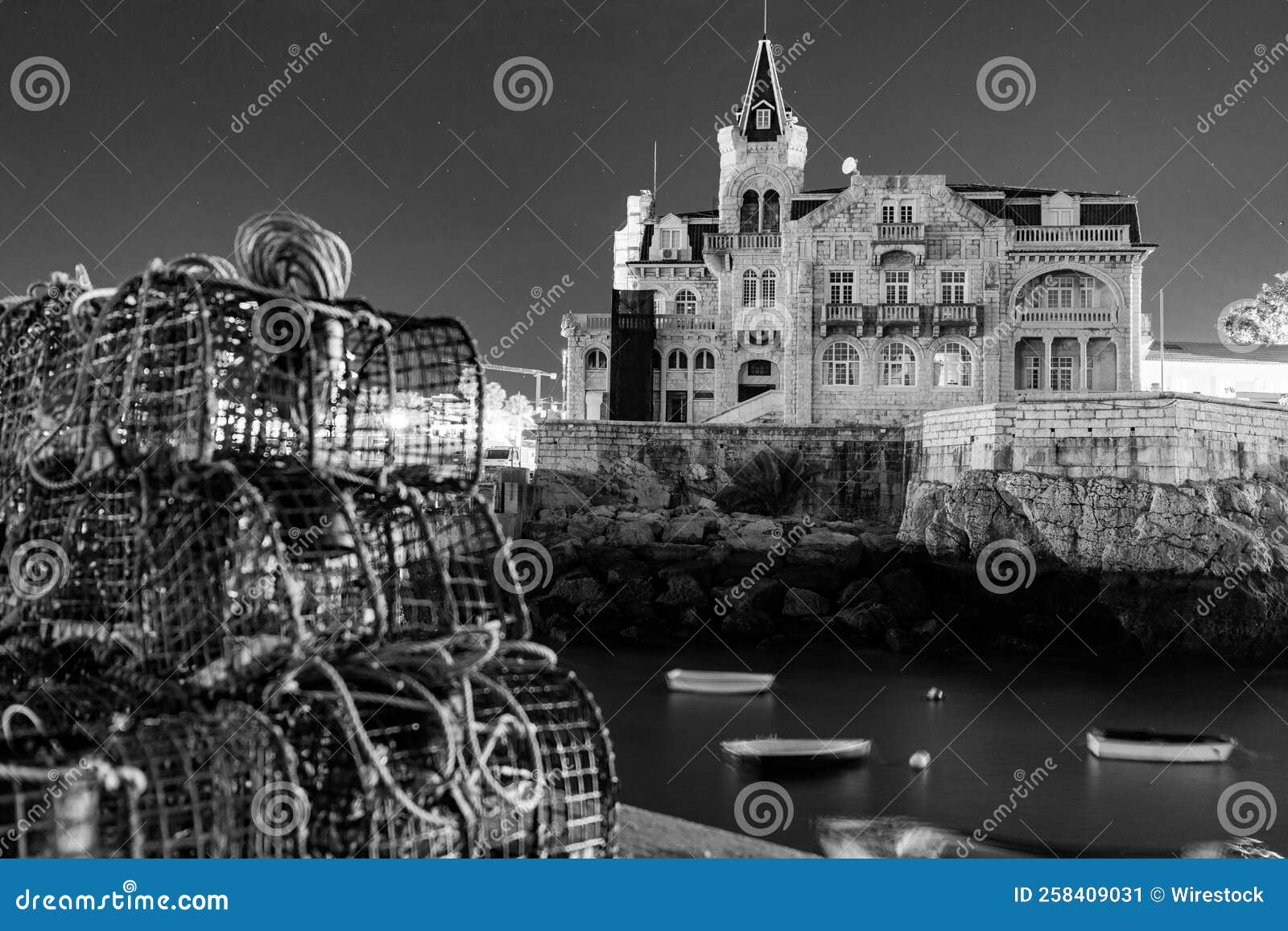 grayscale of beautiful palacete seixas in cascais seen through blurred fishing nets