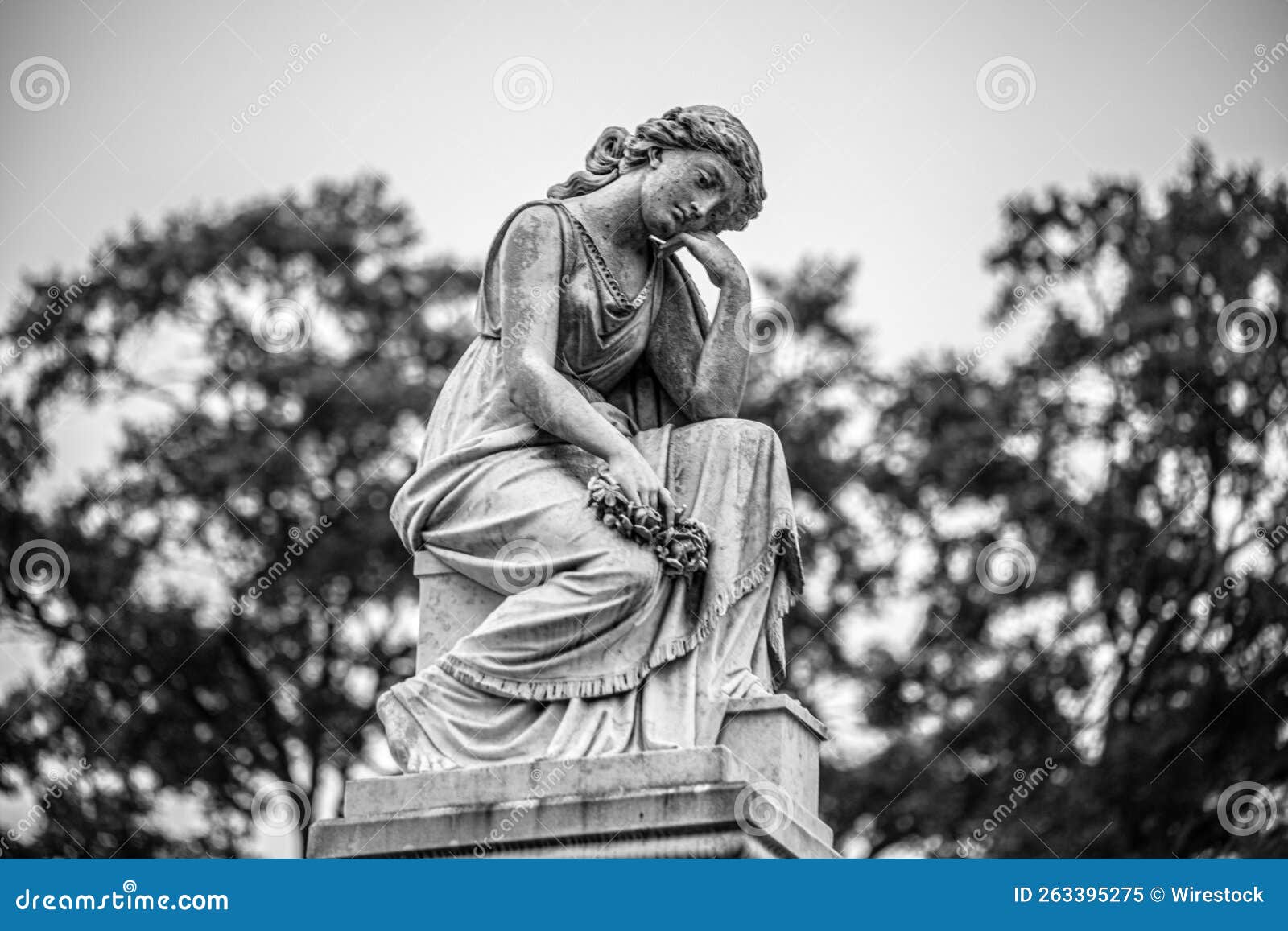 grayscale view of a sad angel statue in loudon park cemetery in baltimore, maryland