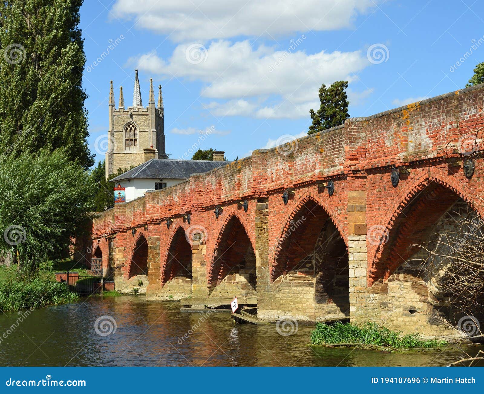 great  barford  packhorse bridge and all saints church  tower. bedfordshire england.