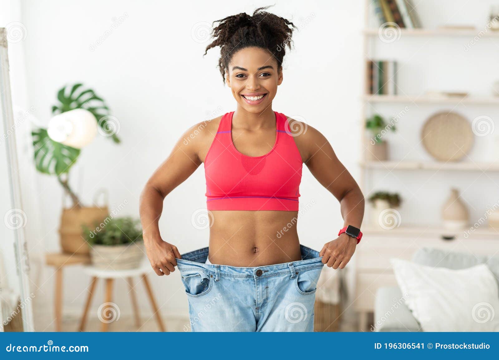 Joyful Slim Black Girl Wearing Old Big Jeans Standing Indoors Stock ...