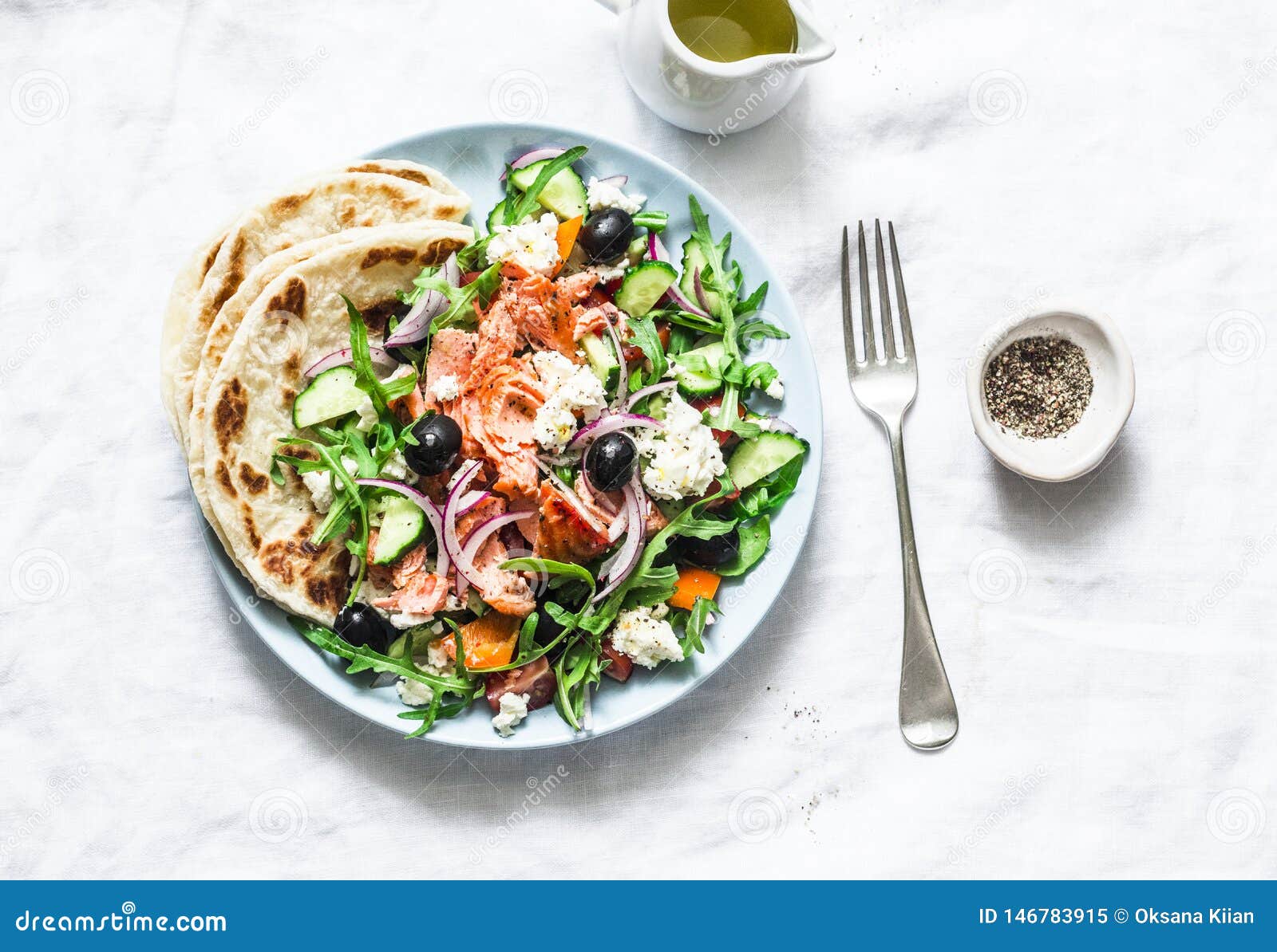greek salad with baked salmon on a light background, top view. healthy mediterranean diet food