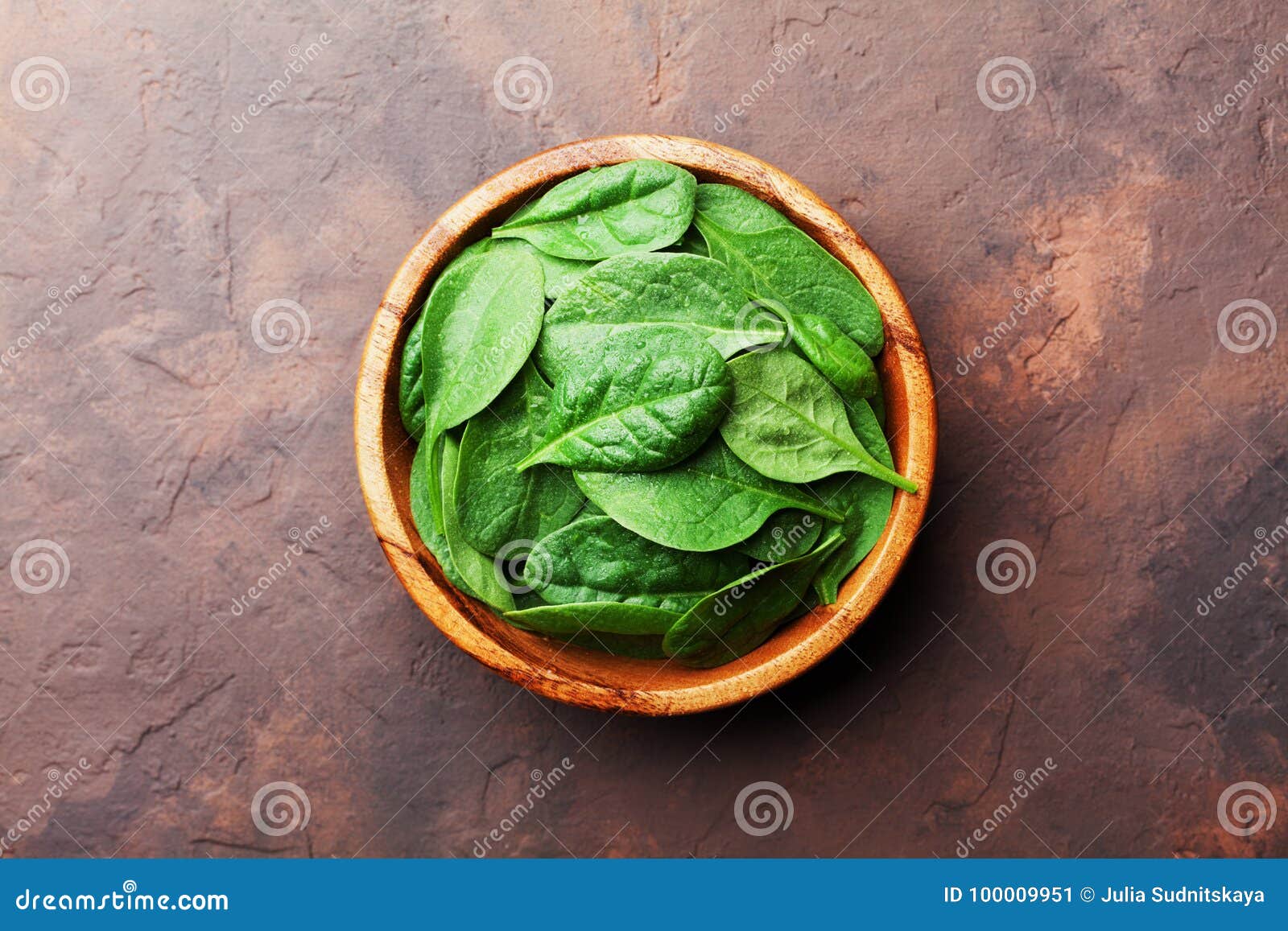 Green Baby Spinach Leaves in Wooden Bowl on Rustic Stone Table Top View
