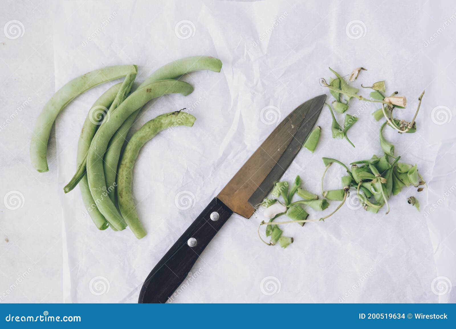 Green Beans and a Knife on a White Surface Cleaning Green Beans Stock
