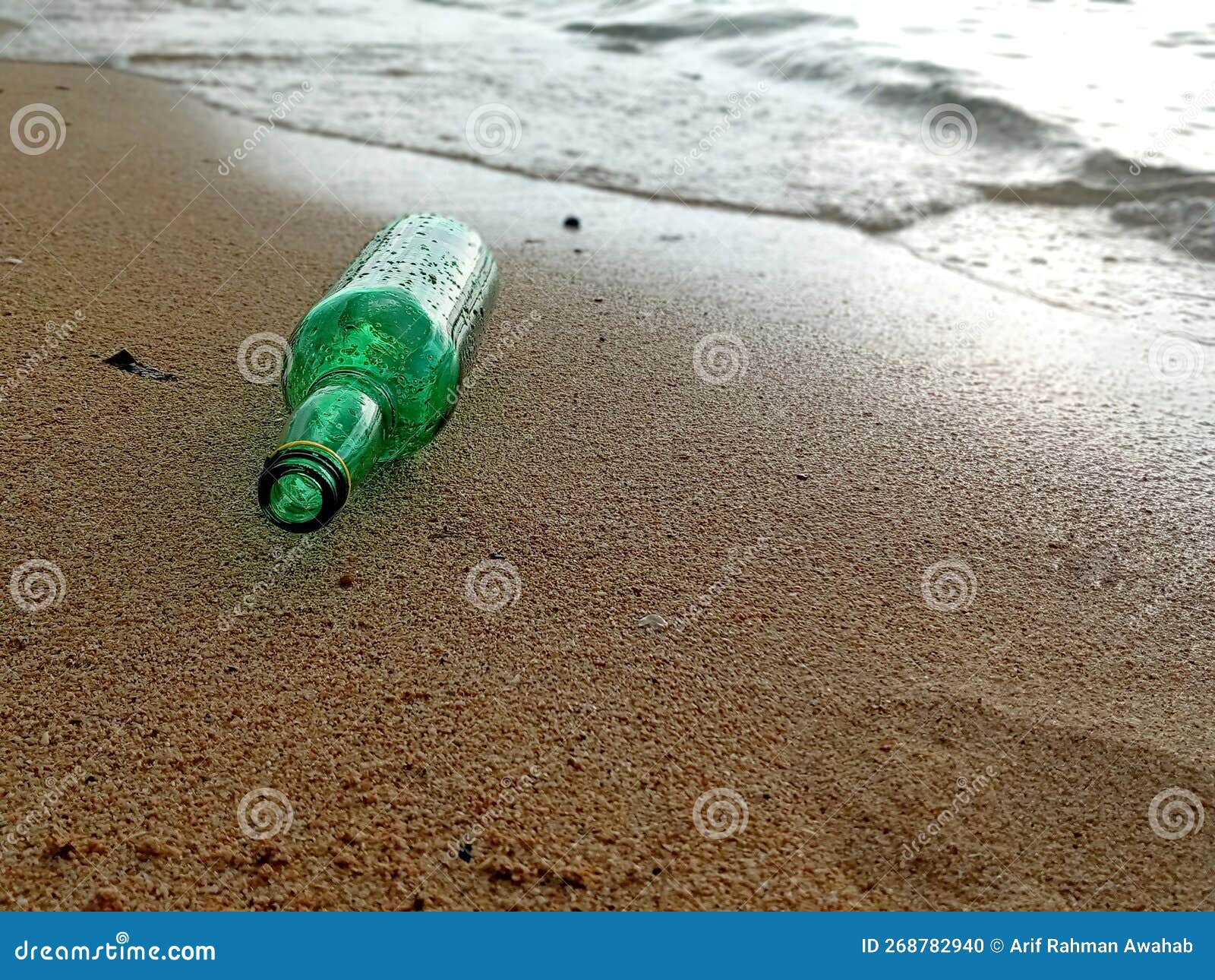 A Green Bottle Lying on the Beach Stock Photo Image of bottle, leaf
