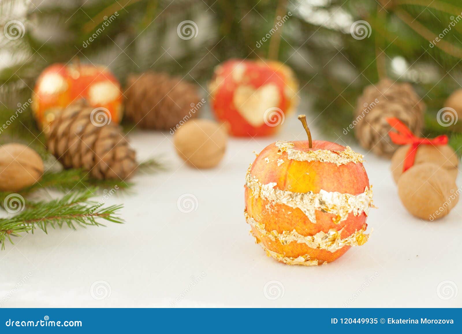 Green branches and christmas golden lights and beautiful apple on white background happy new year