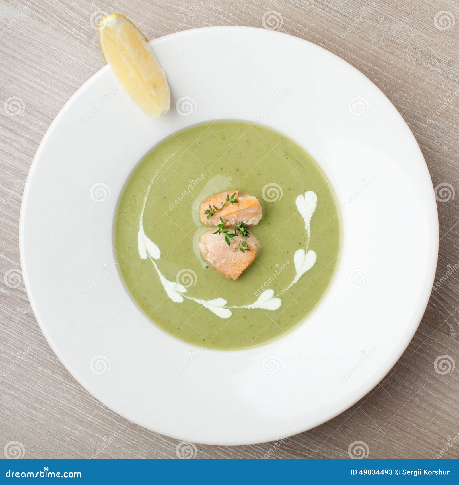 green broccoli cream soup puree with filleted salmon and lemon