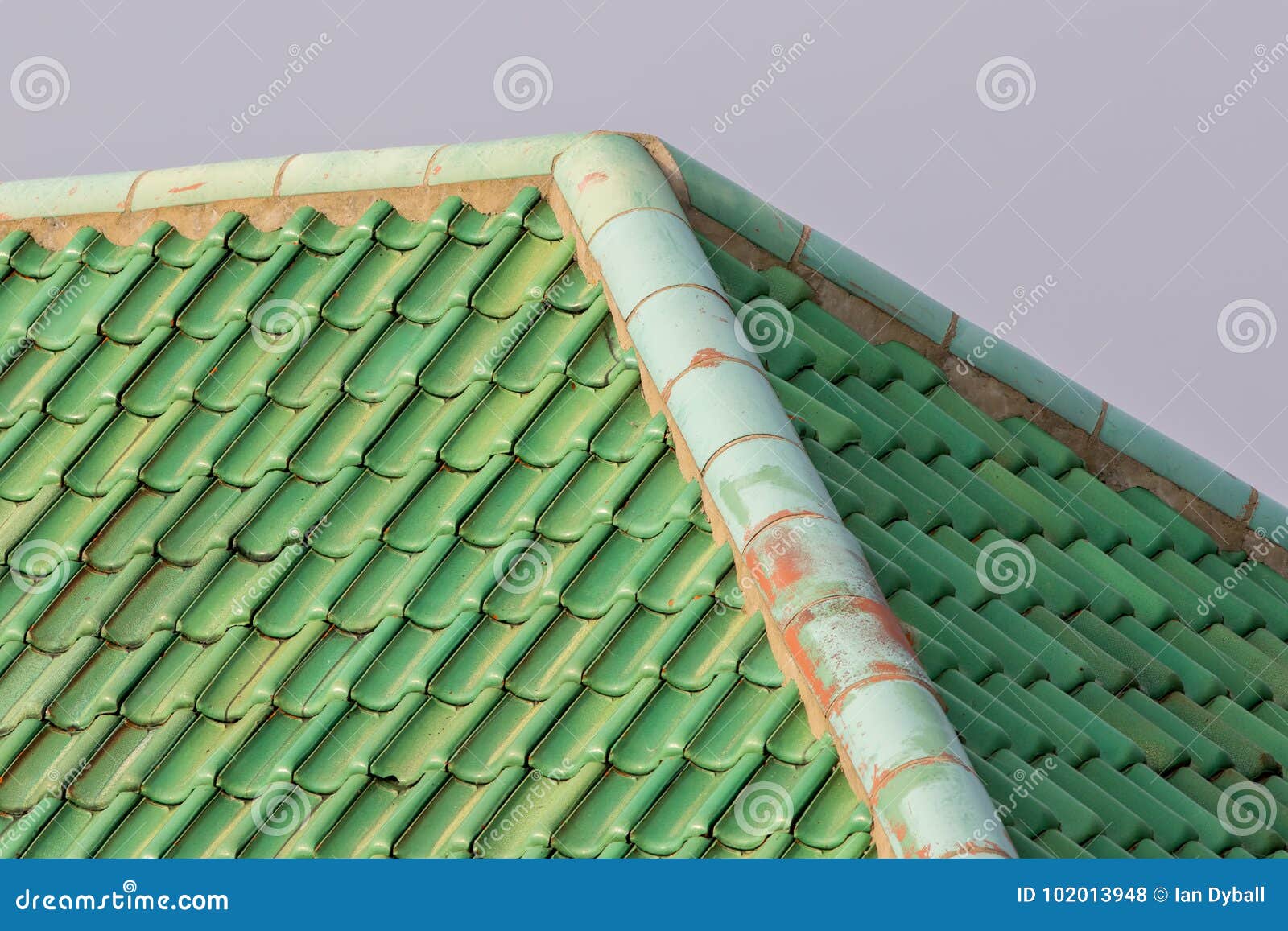 Green Colored Curved Clay Roof Tiles with Ridge Corner. Stock Photo
