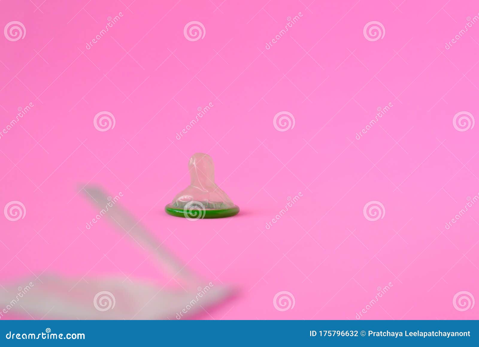 Green Condom On Pink Paper Background With Copy Space For Text