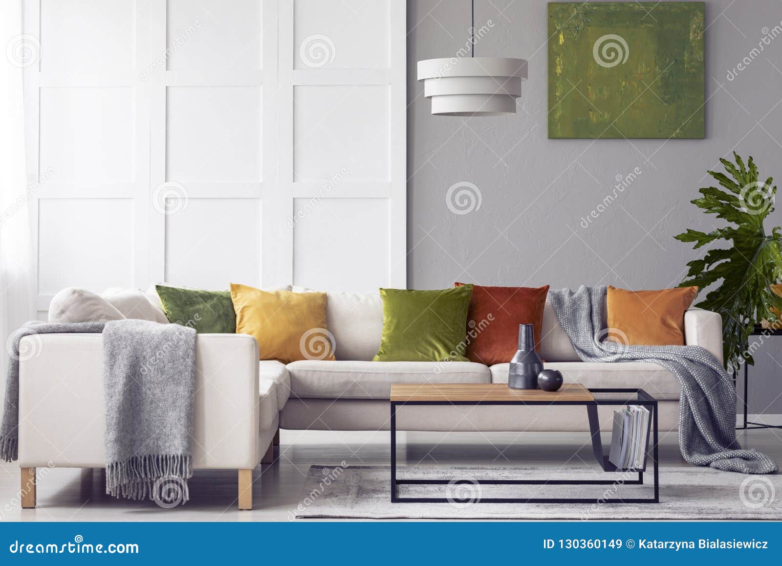Green Cushions And Grey Blanket On Corner Sofa In Living