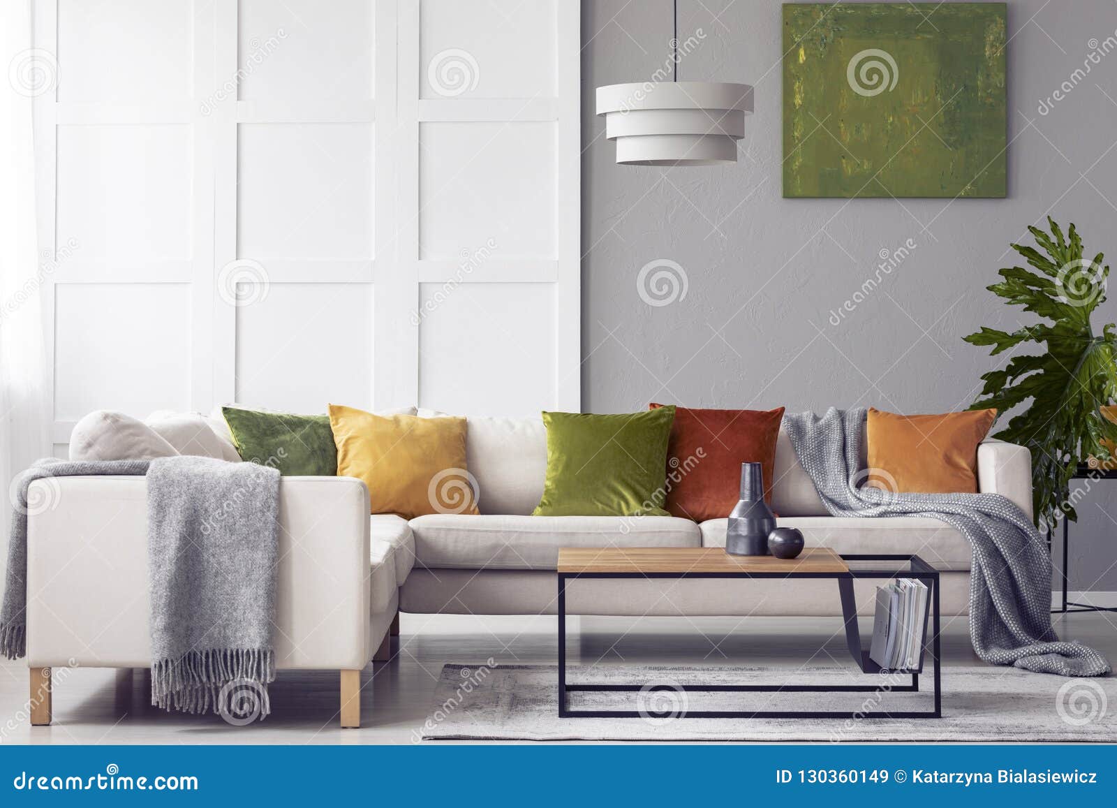 Green Cushions And Grey Blanket On Corner Sofa In Living 