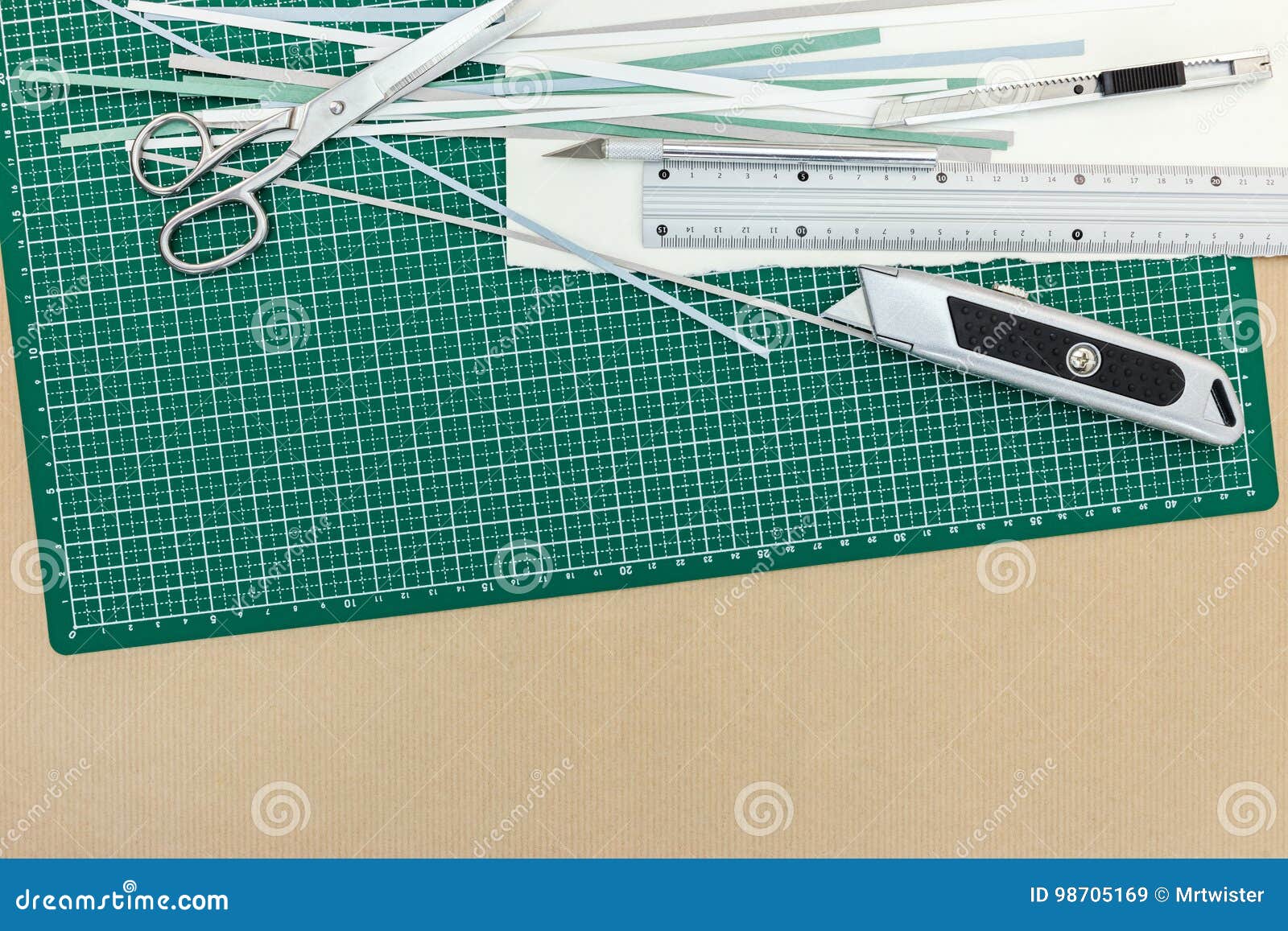 Green Cutting Mat With Scissors Cutter And Metal Ruler On Desk