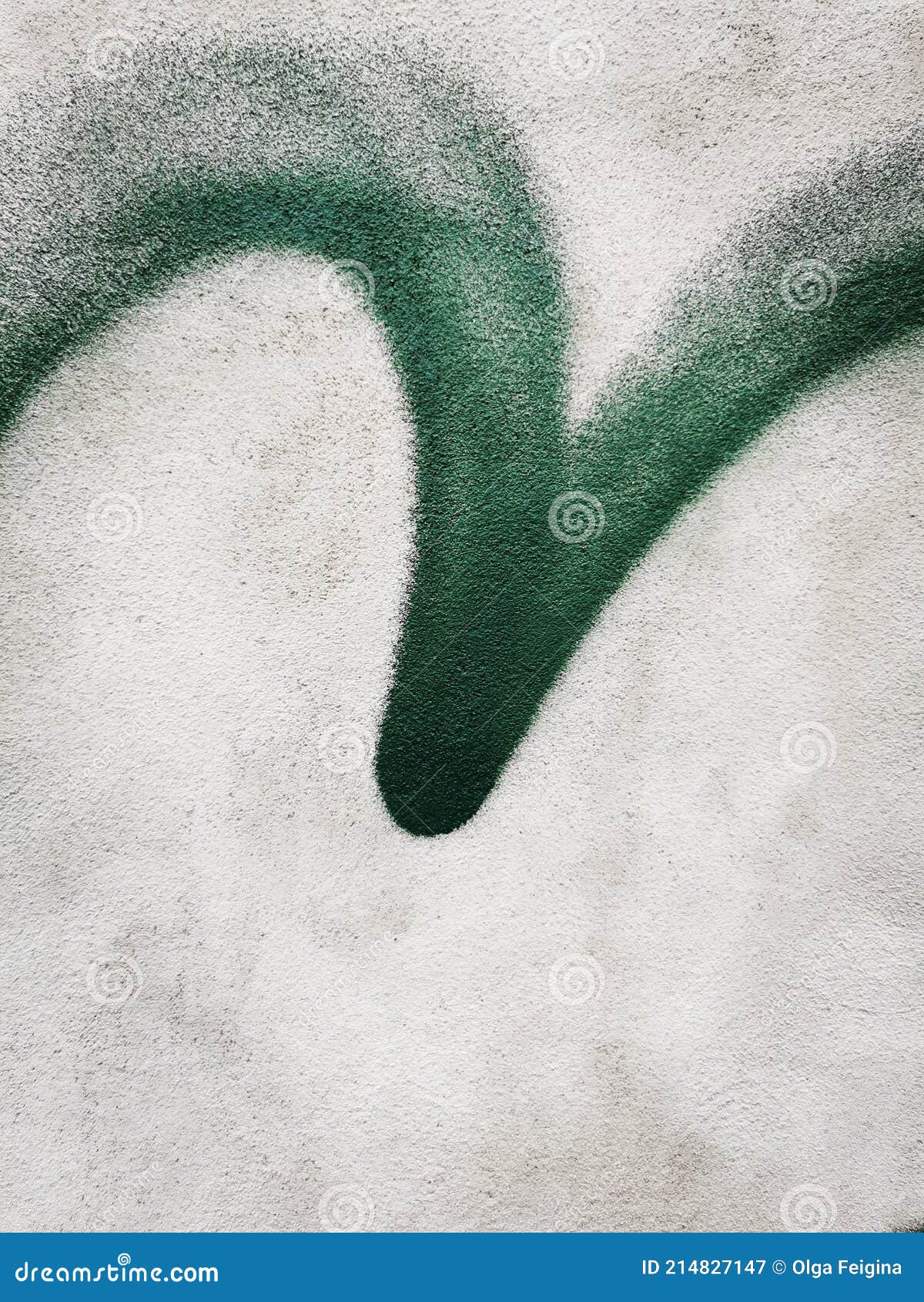 green emulsified check mark on concrete wall.