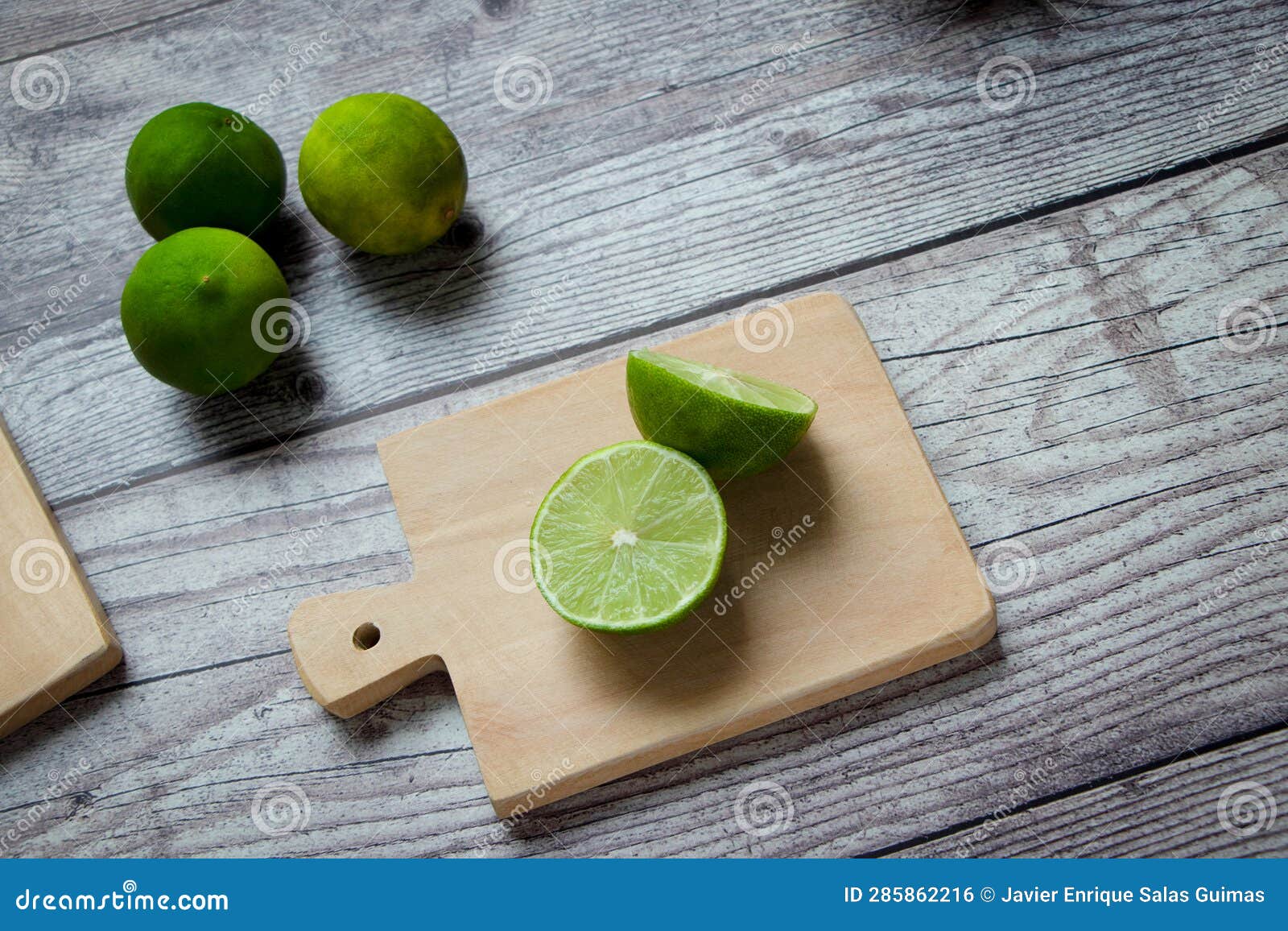 green lemons on a chopping board